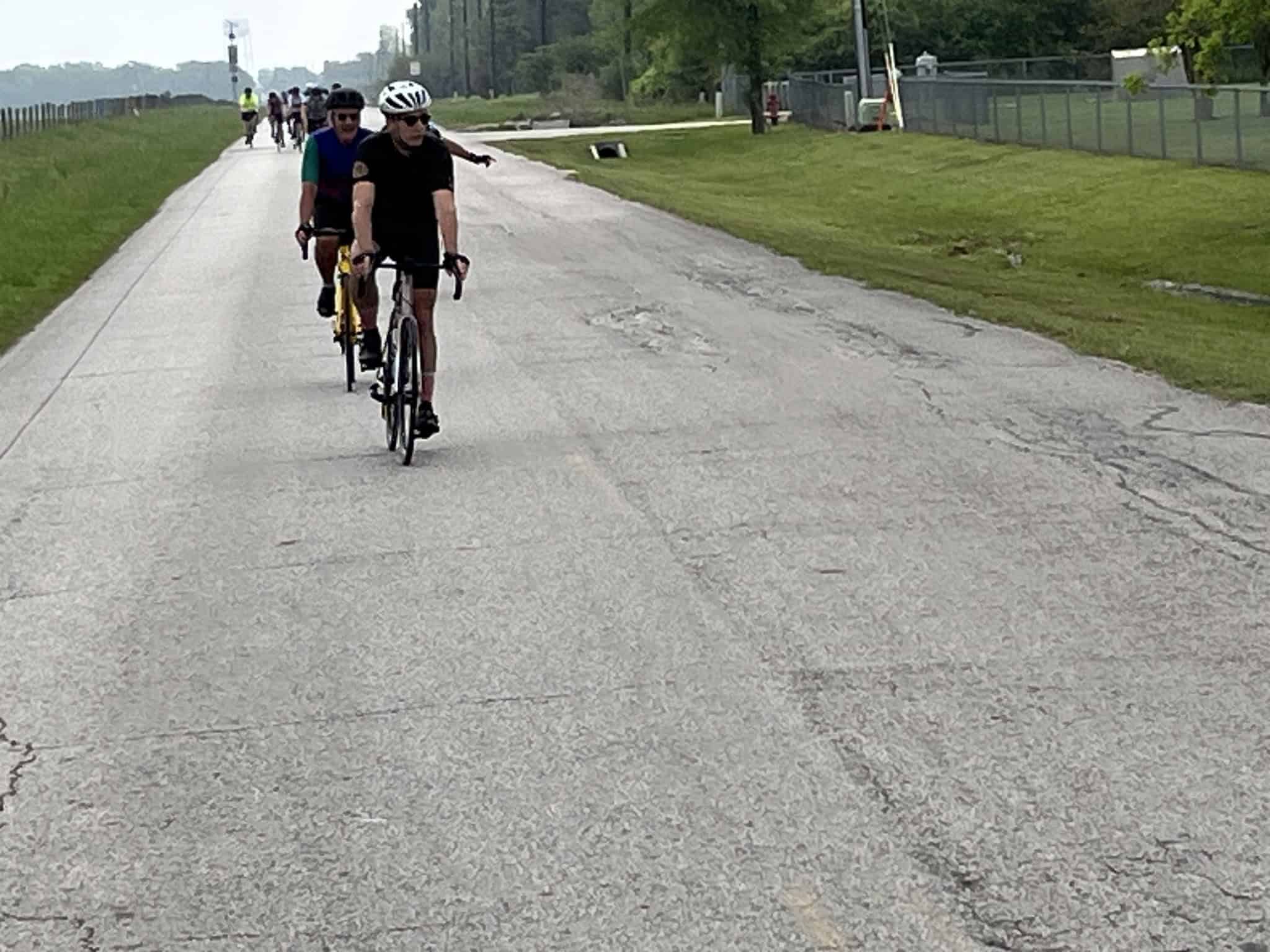 Cyclists riding on a paved trail during daytime, part of the Bluebonnet Express biking event.