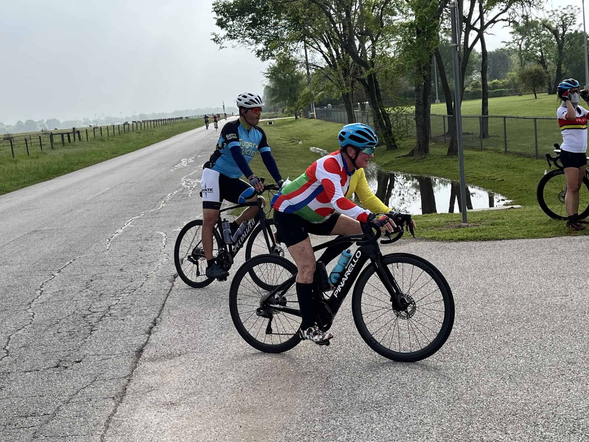 Vibrant cyclists riding on scenic bike trail at Bluebonnet Express event.