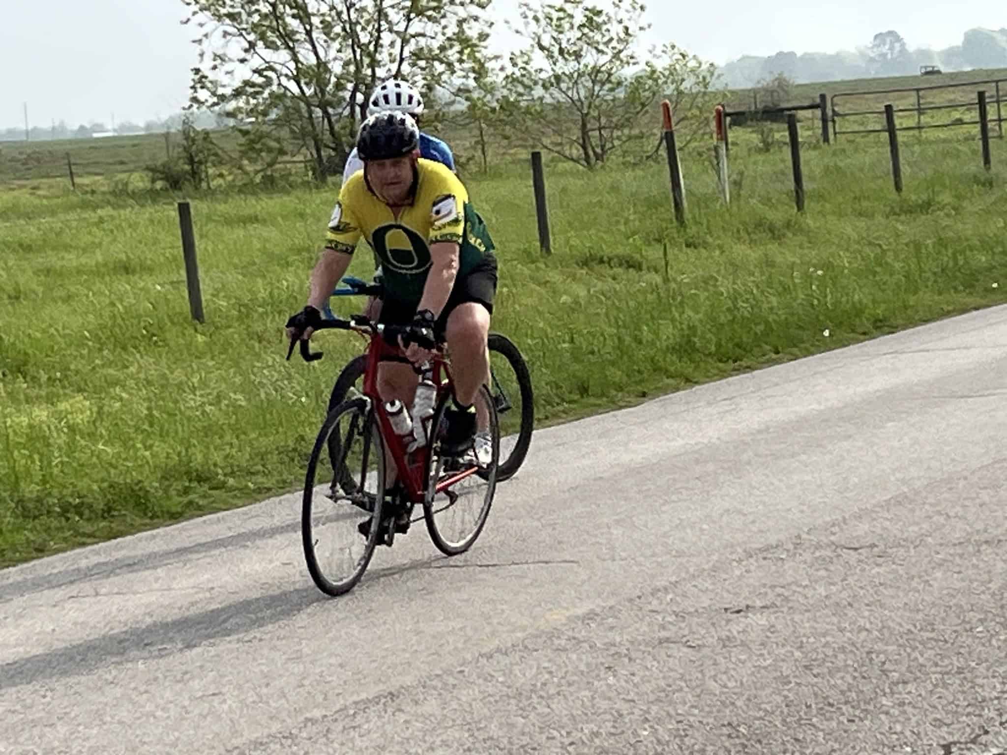 Cyclist riding on scenic rural road, promoting Bluebonnet Express bike tours and outdoor adventure.