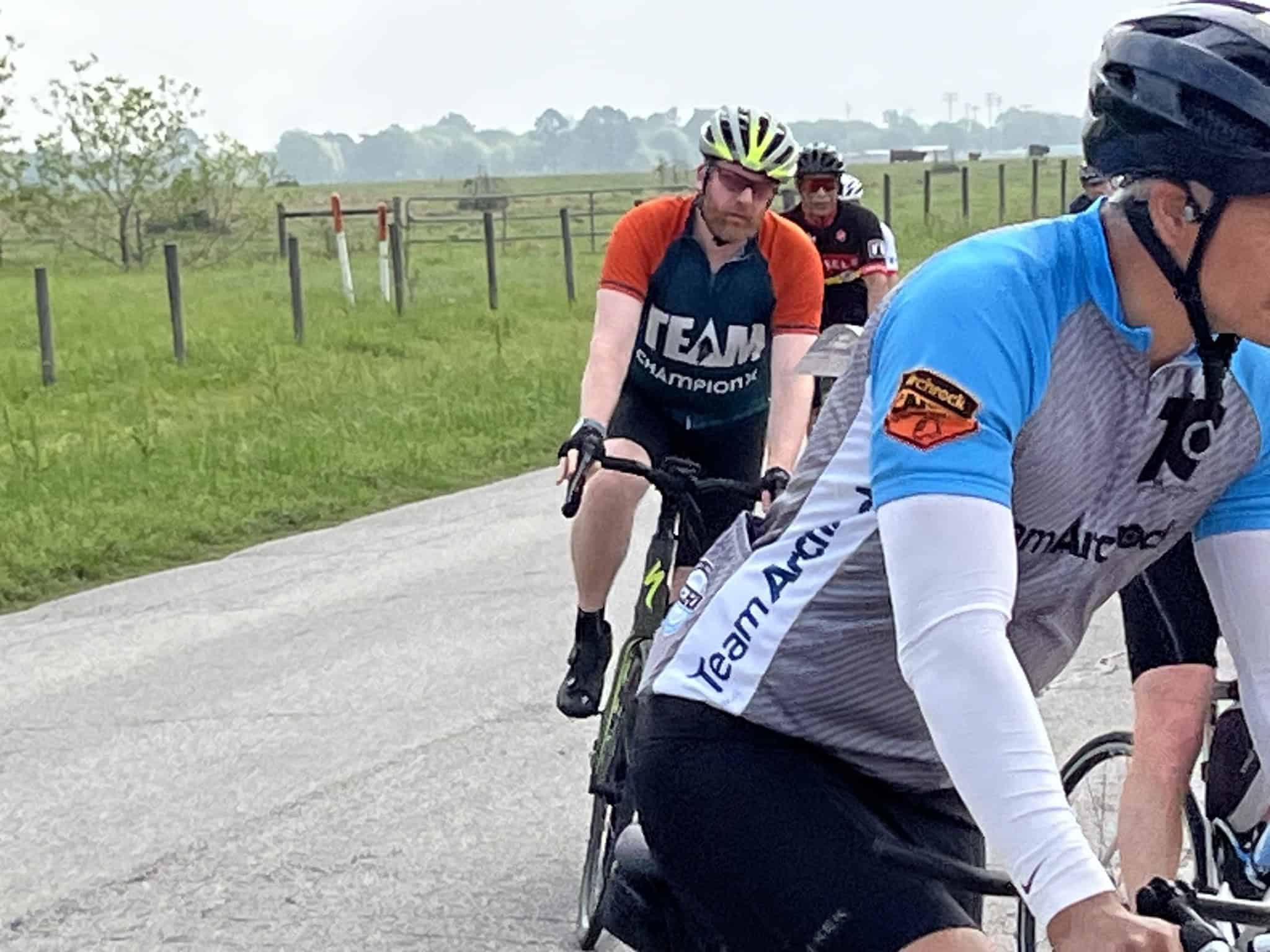 Bicycle riders participating in Bluebonnet Express cycling event on scenic rural road.