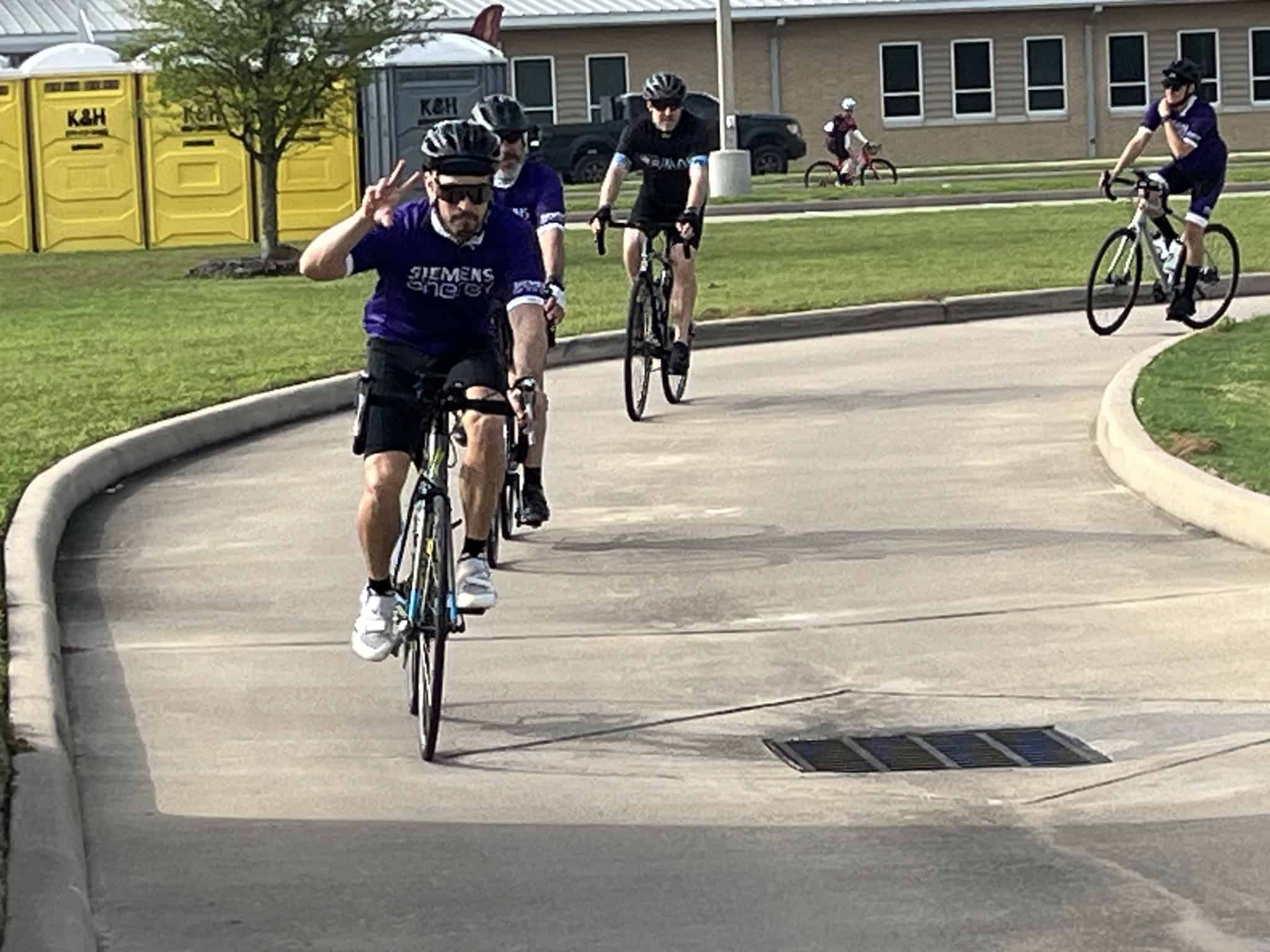 Bike riders in Bluebonnet Express cycling event, enjoying a sunny day on a scenic park trail.