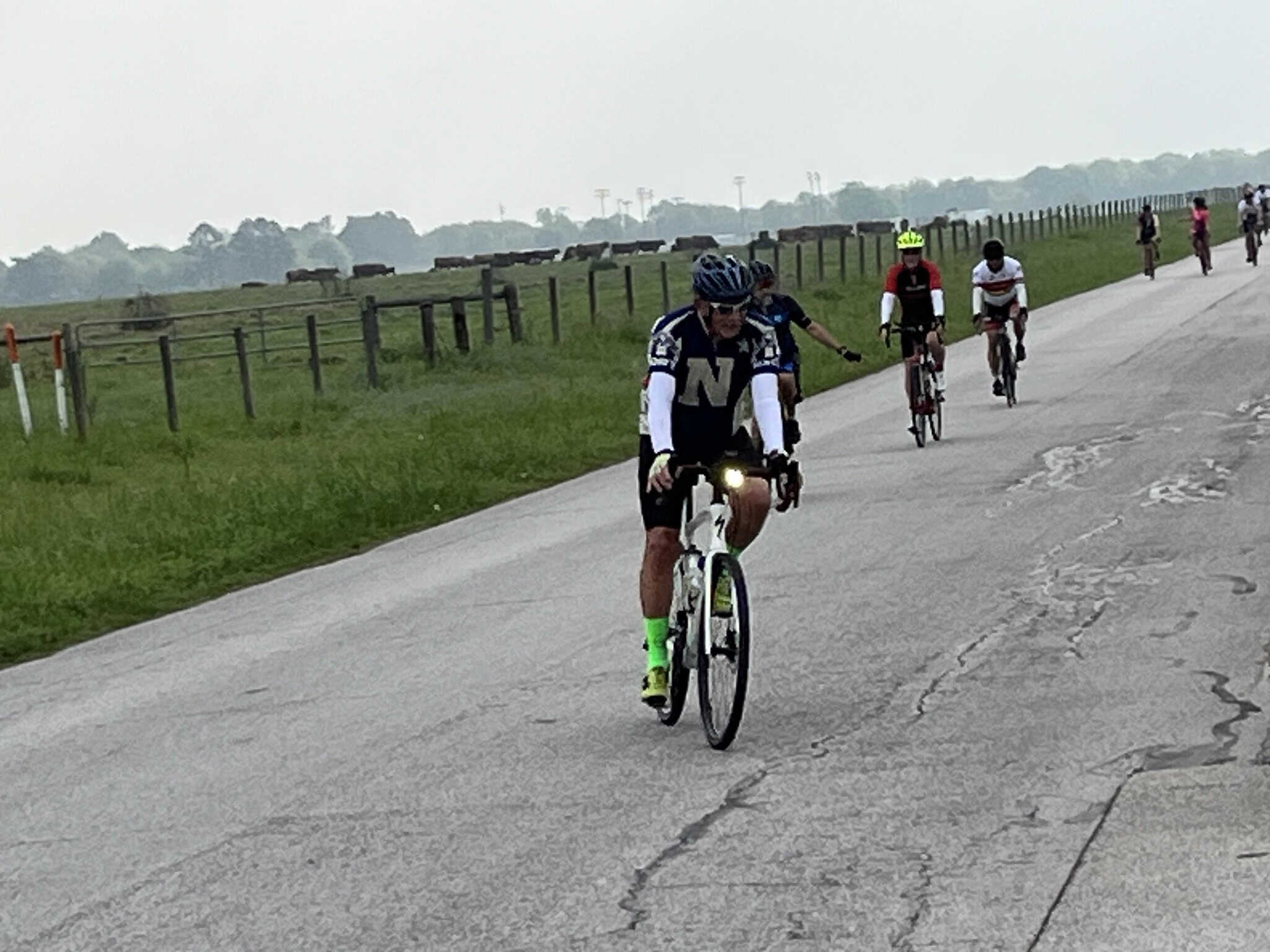 Vibrant cyclists riding on scenic country road showcasing Texas Bluebonnet Express bike event.