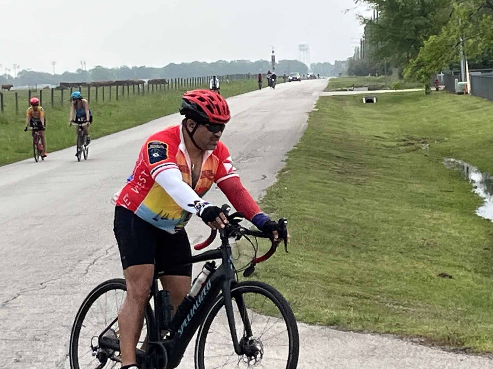 Bright cyclist wearing a colorful jersey riding on the Bluebonnet Express bike trail, enjoying a scenic ride in Texas.