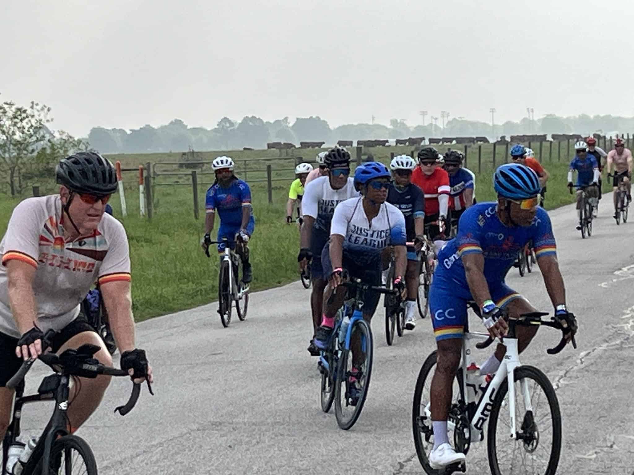 Vibrant cyclists participating in a group ride along scenic rural roads, promoting fitness and community biking events.