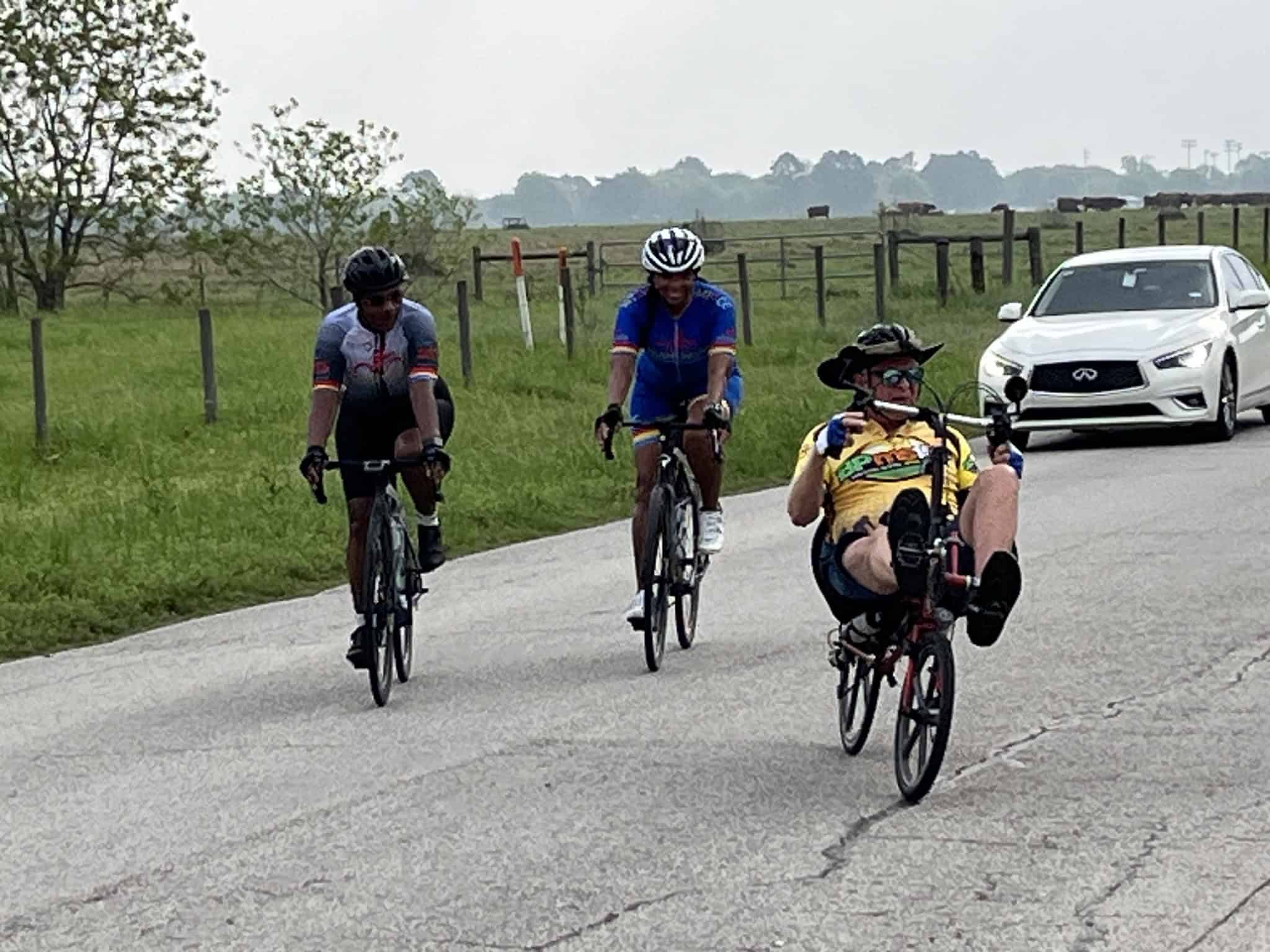 Riders enjoying a scenic bike ride on a rural road near Bluebonnet Express, showcasing outdoor cycling adventure and nature.