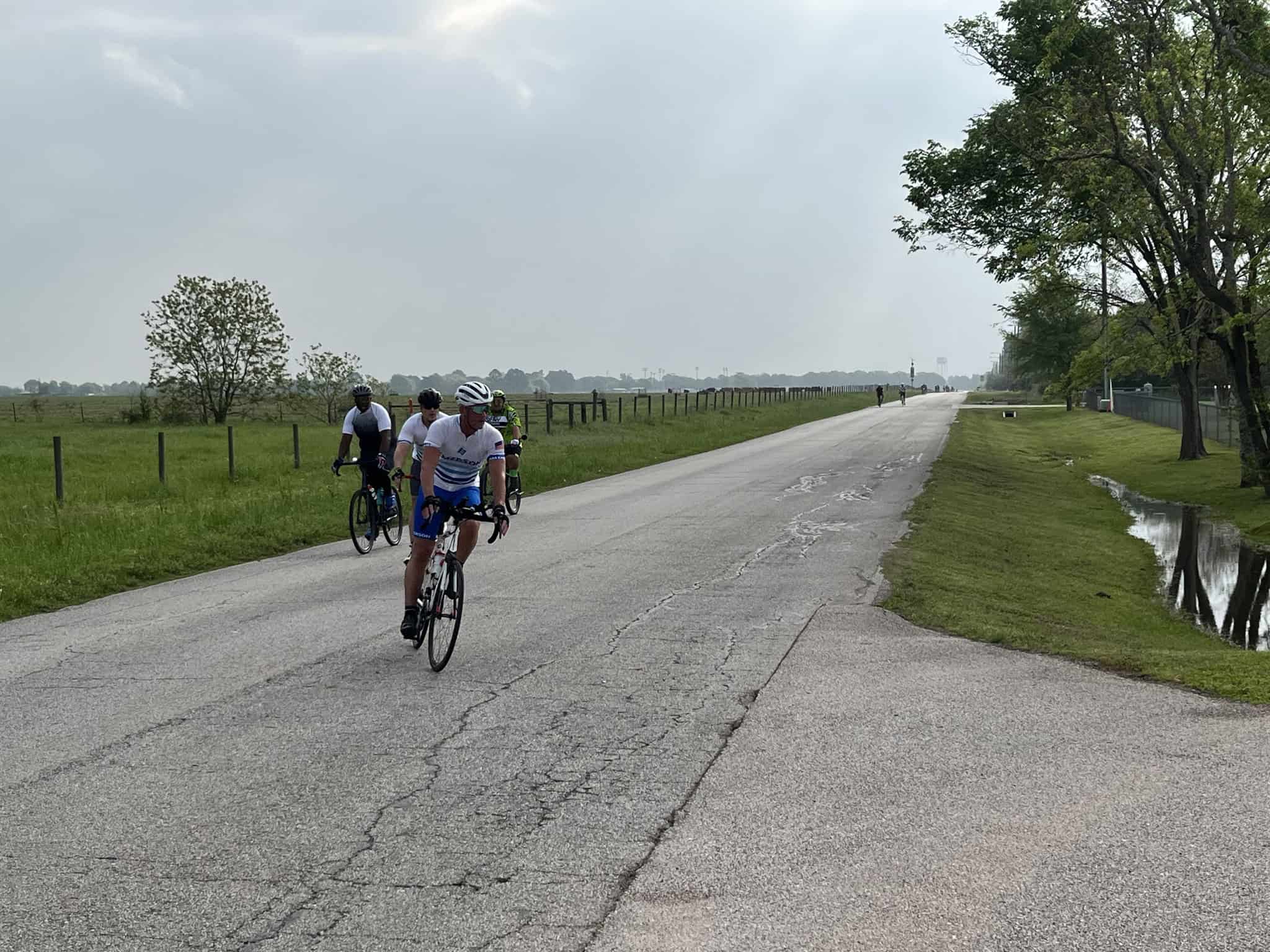 Cyclists riding along a scenic, open road in Texas near Bluebonnet fields, enjoying outdoor bike rides and nature.