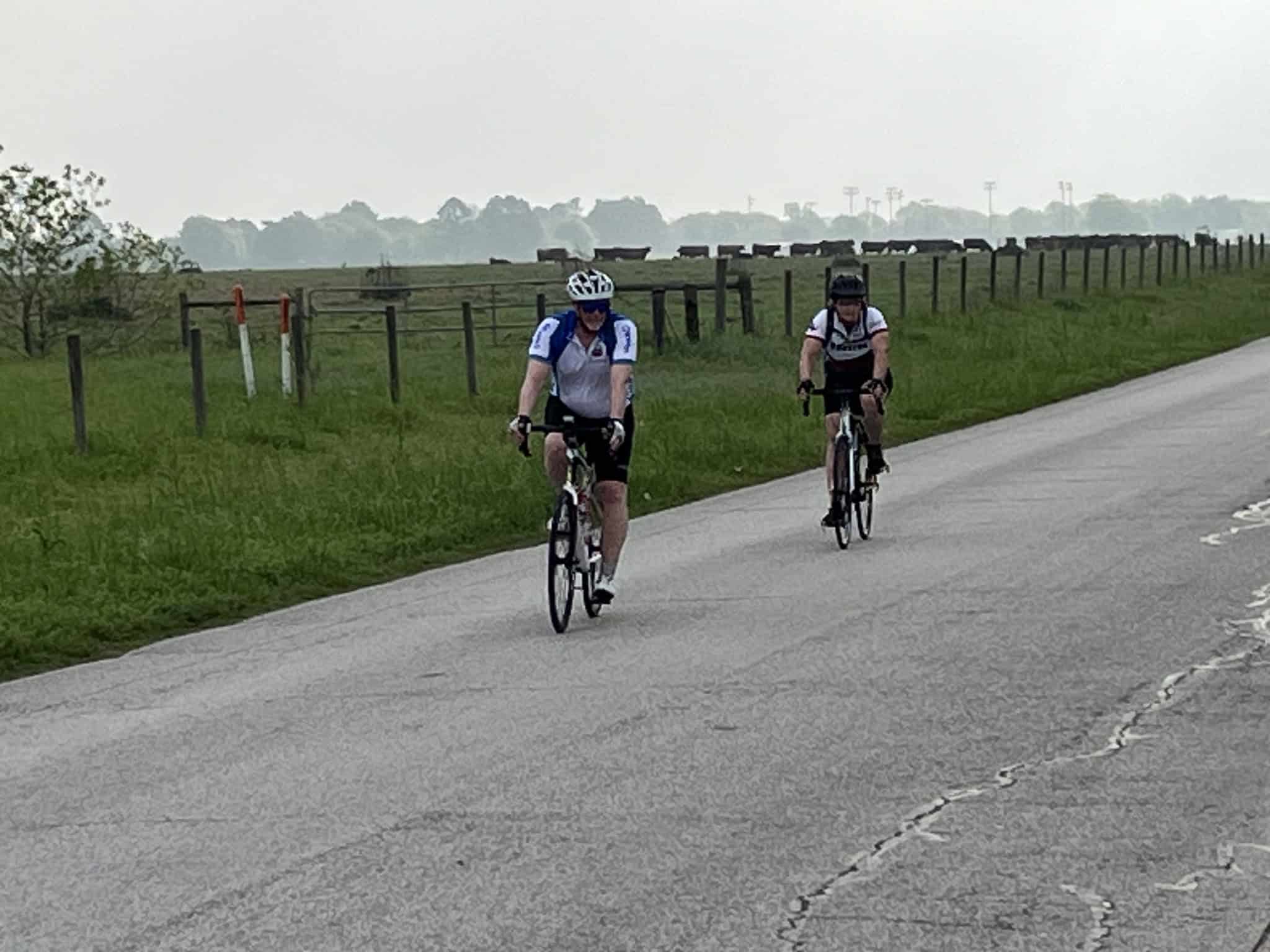 Brightly colored cyclists riding on a scenic rural road for Bluebonnet Express bike event.