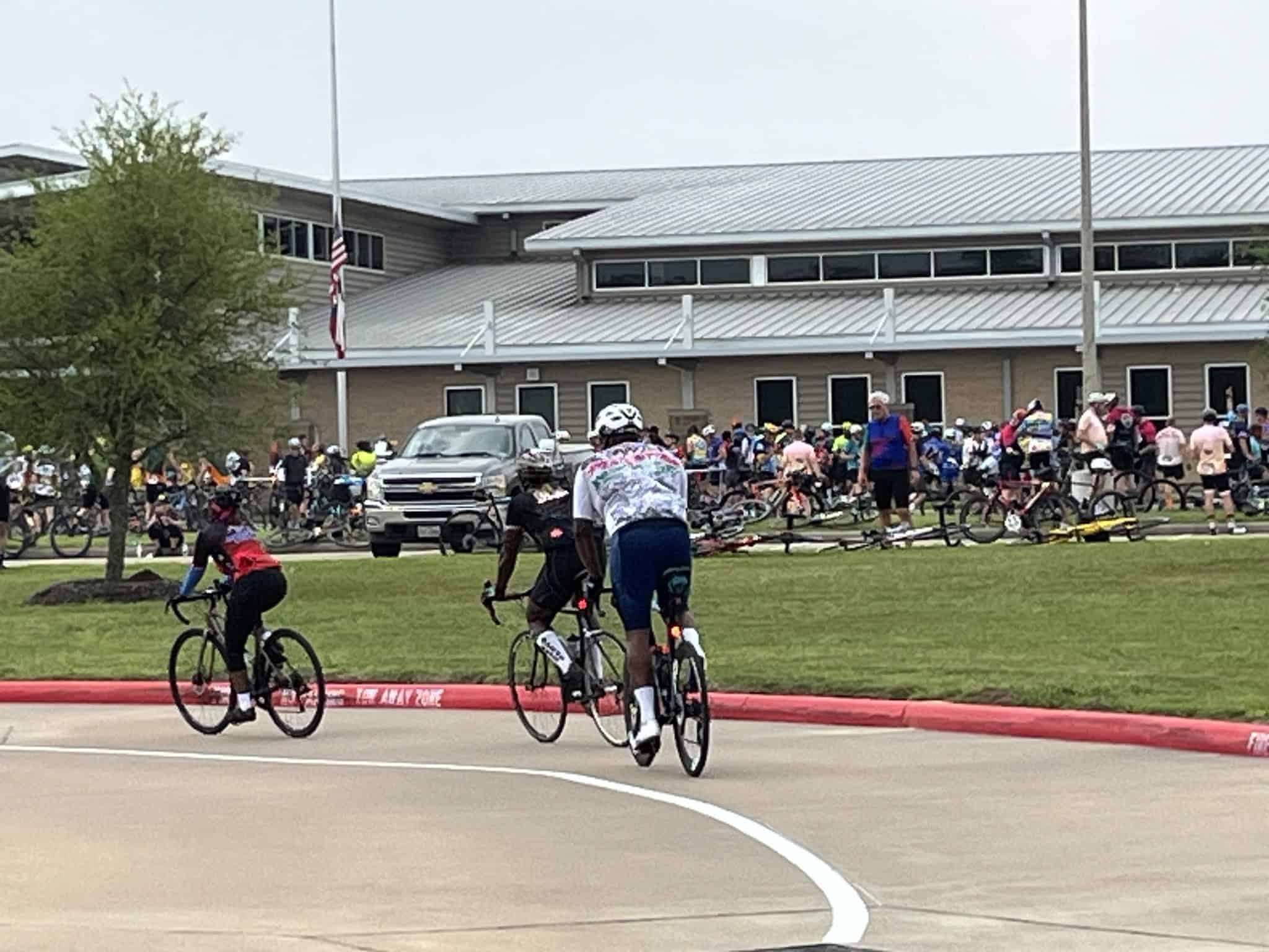 Cyclists participating in Bluebonnet Express bike event at a busy outdoor venue.