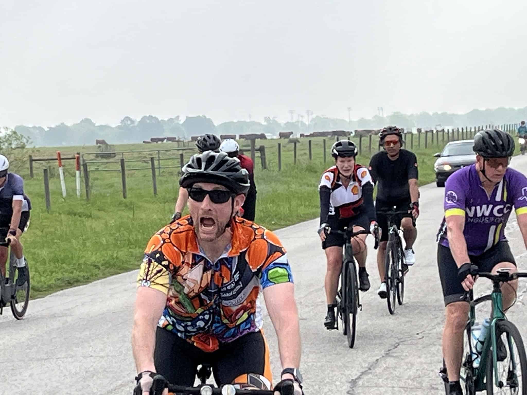 Vibrant group of cyclists riding through scenic countryside during Bluebonnet Express event.