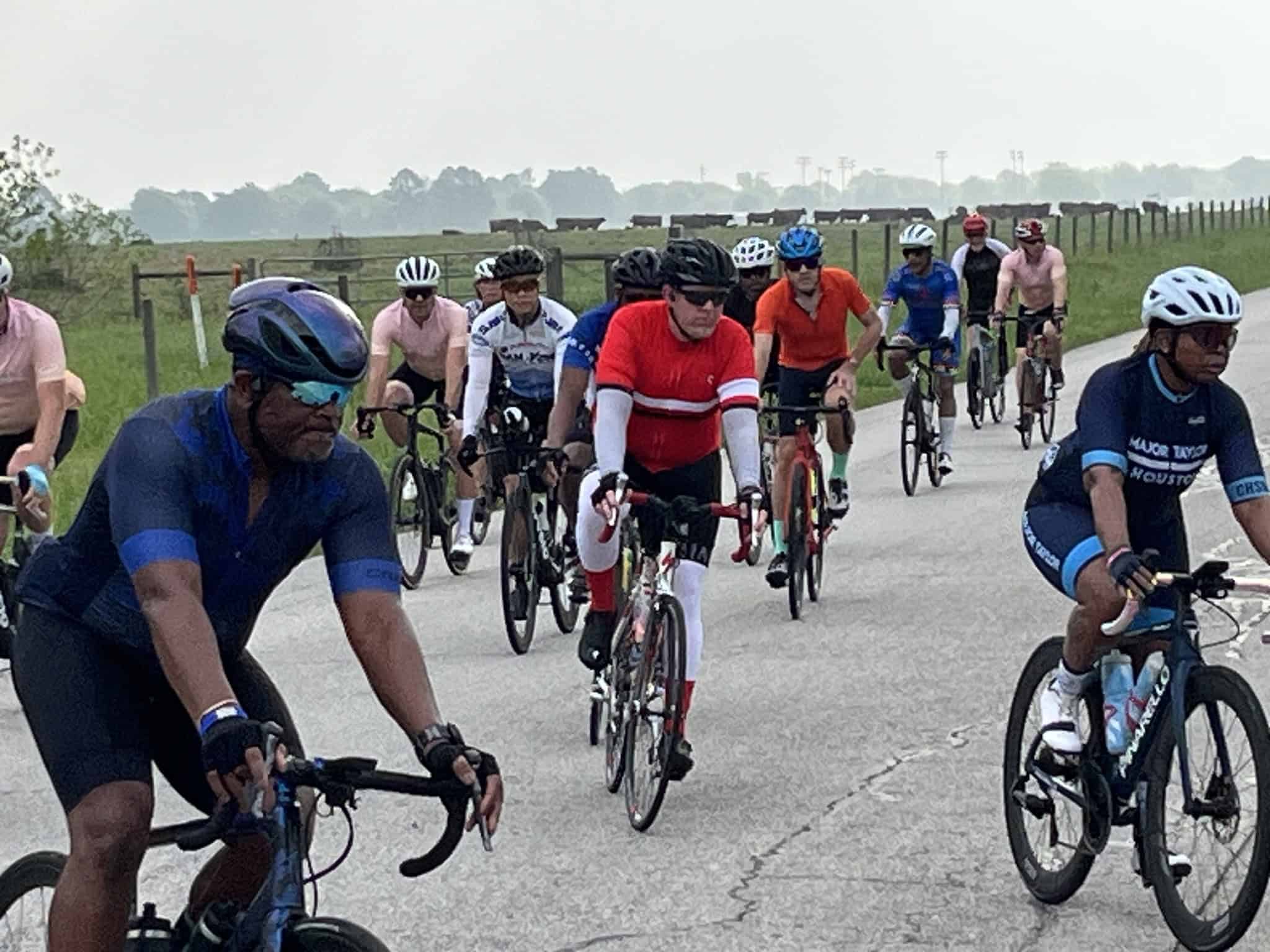 Bicycle riders participating in the Bluebonnet Express cycling event on scenic rural roads.