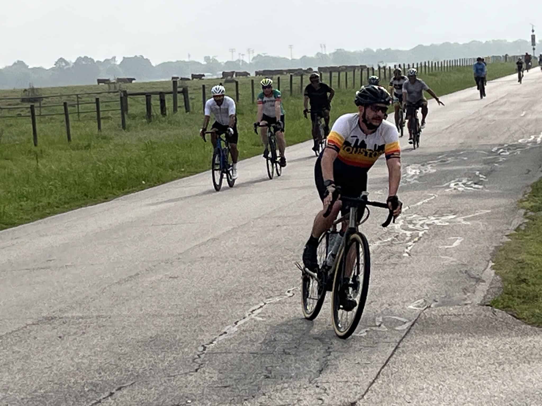 Riders cycling on a scenic rural trail outdoors in a group.