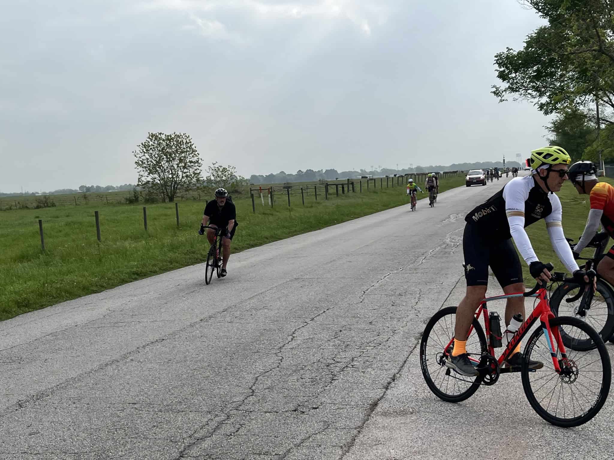 Cyclists riding on a rural road, featuring Bluebonnet Express cycling event, outdoor recreation, and scenic Texas countryside.