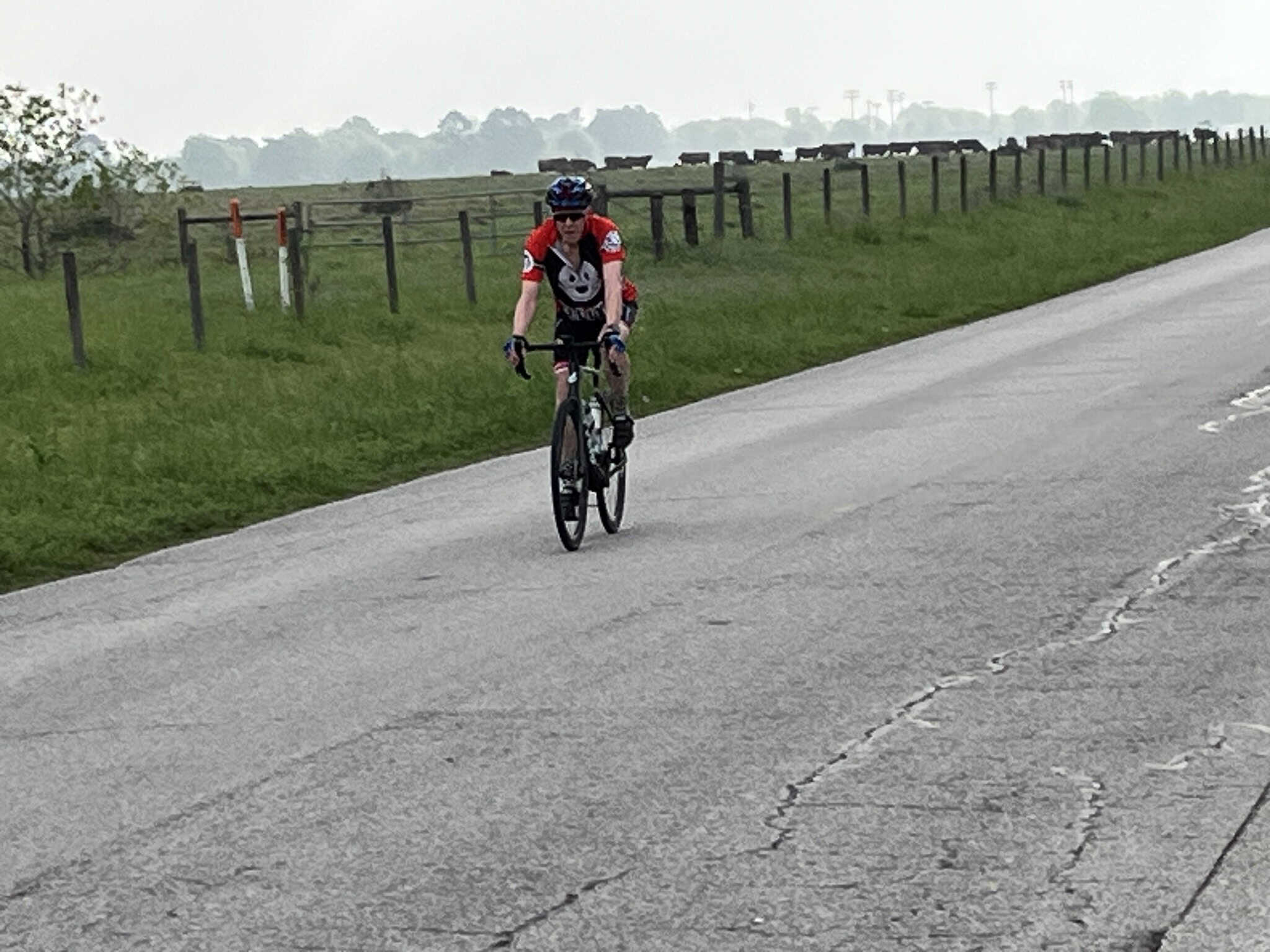 Rider on a bicycle riding along a scenic rural road in Texas, representing Bluebonnet Express cycling event.