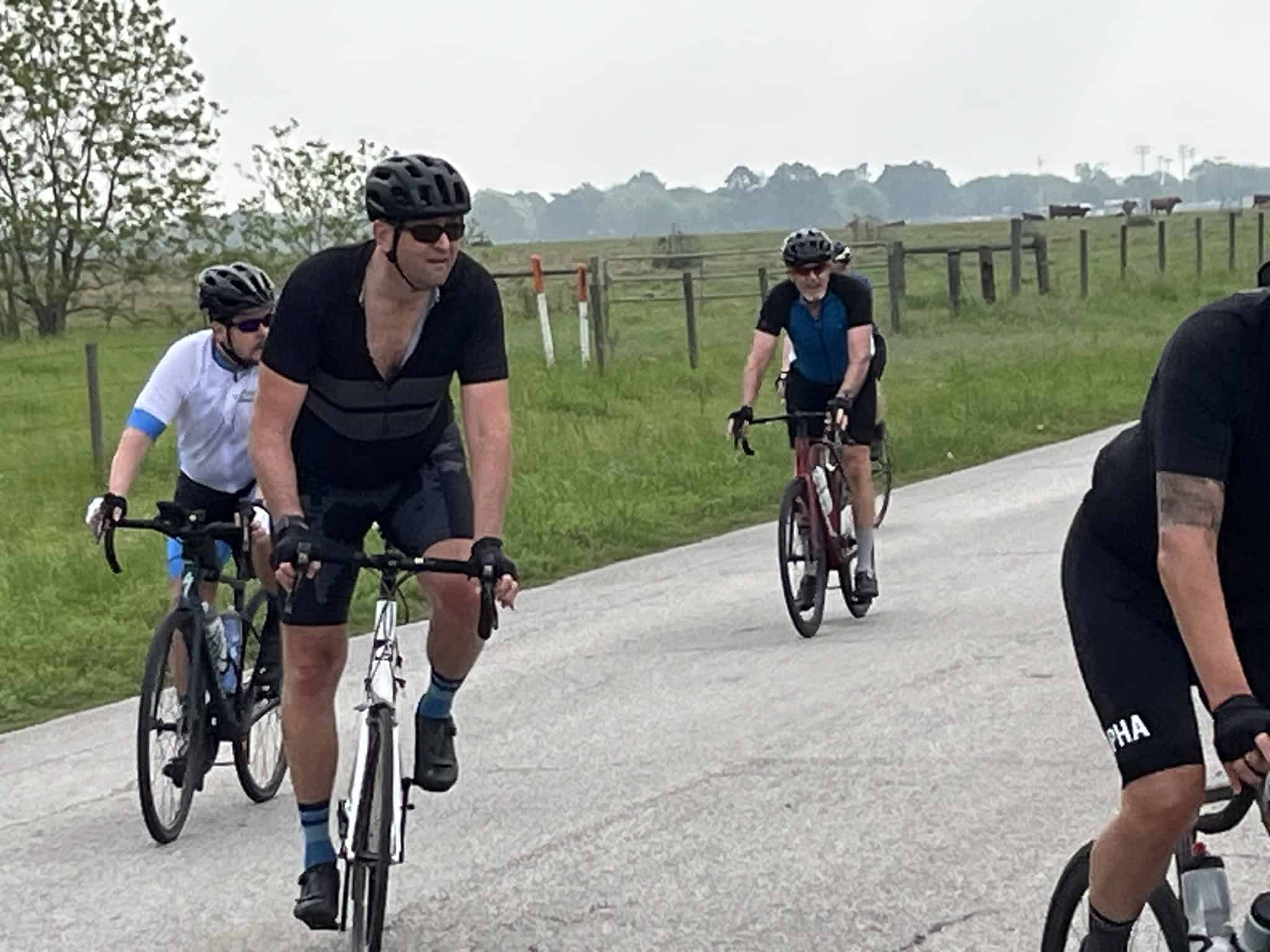 Cyclists riding along a rural road during the Bluebonnet Express event, enjoying scenic Texas countryside.
