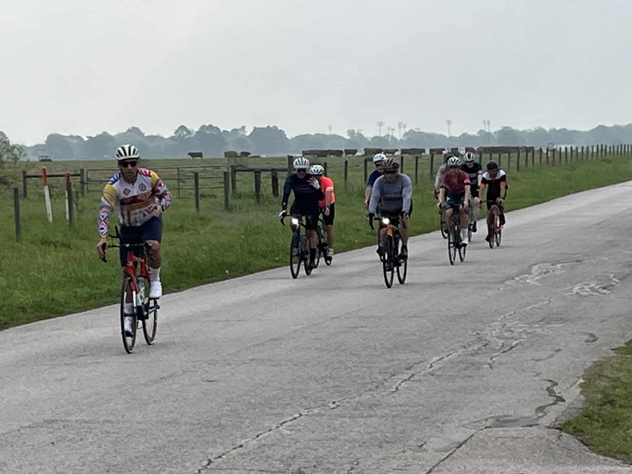 Cyclists riding along a rural road in the Bluebonnet Express event, showcasing outdoor biking and scenic Texas countryside.