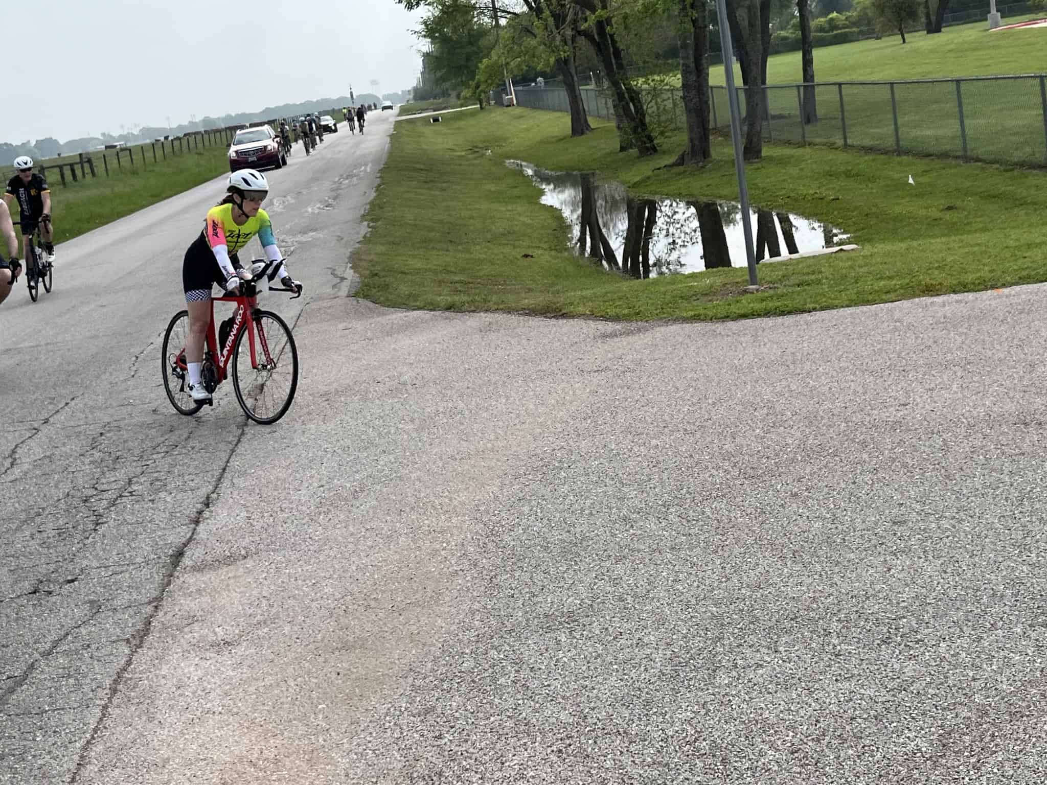 Cyclist on scenic bike trail near water fountain, outdoor biking adventure, urban cycling route, fitness, recreation, sustainable transportation.