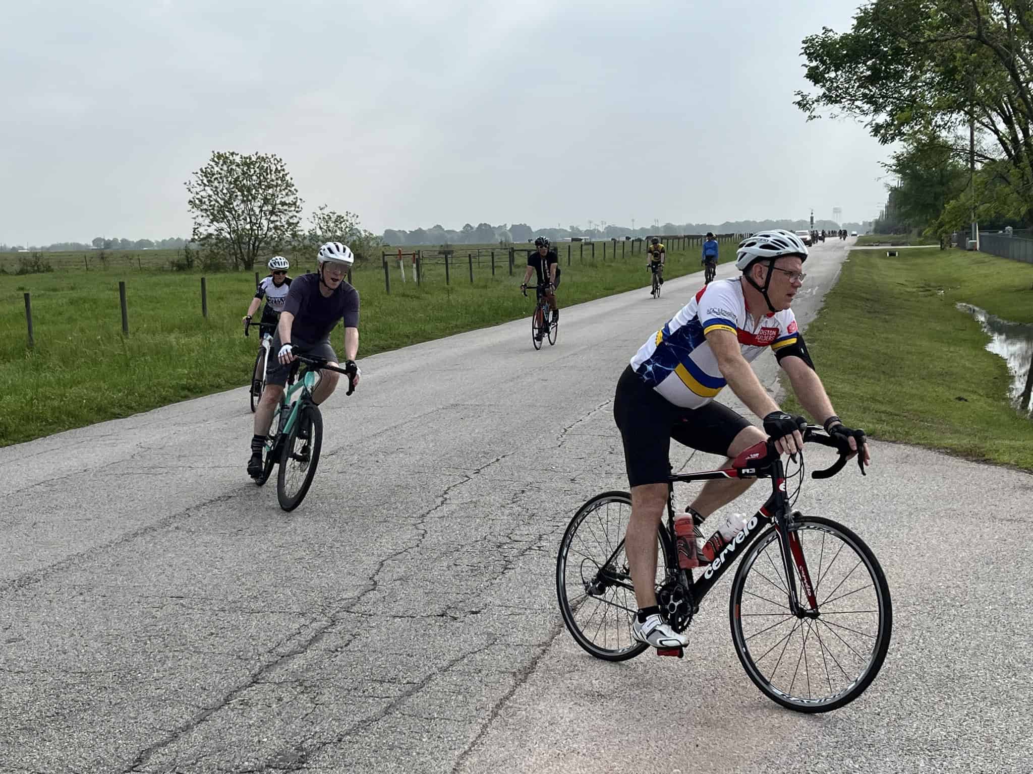 Cyclists riding on a rural road, promoting Bluebonnet Express cycling event, outdoor activity.