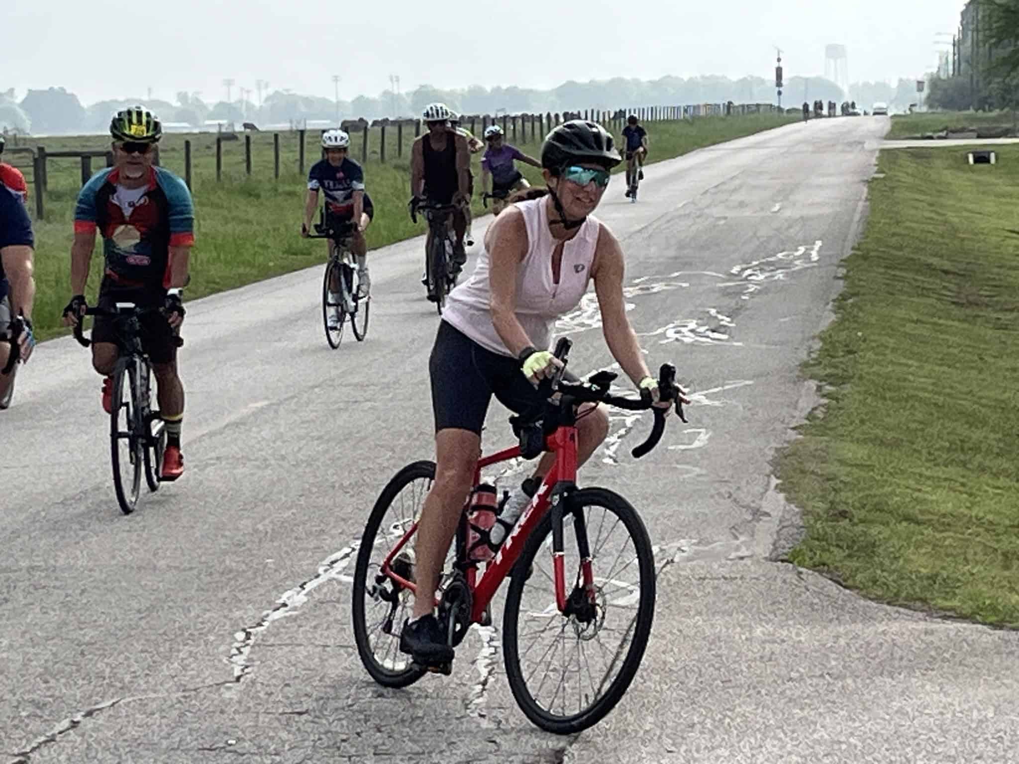 Enjoying a group bike ride along a scenic, open rural path, focusing on outdoor cycling and fitness.