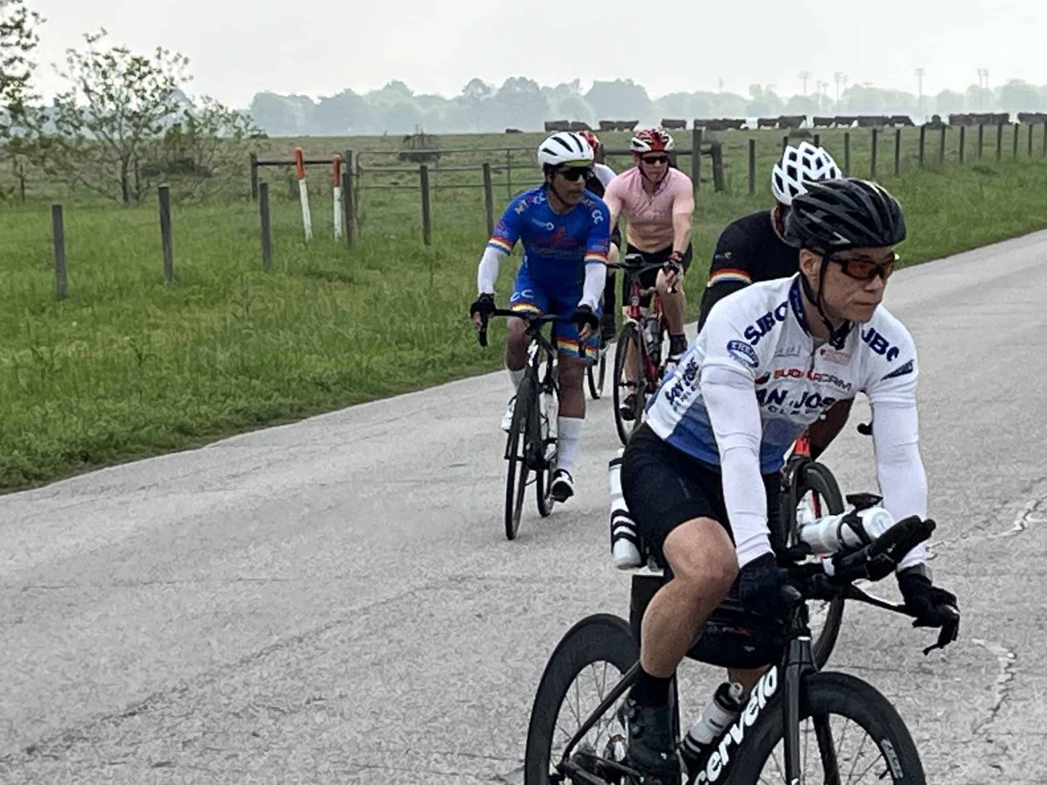 Cyclists riding on a rural road during a Bluebonnet Express bicycle event, enjoying outdoor cycling and scenic views.