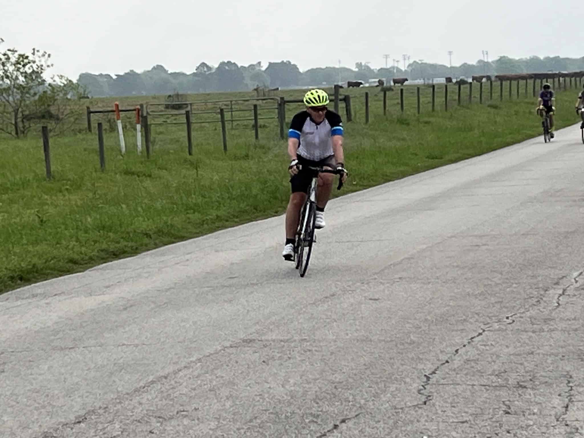 Bright yellow helmet, cyclist on scenic rural bike route, outdoor biking, Bluebonnet Express, Texas countryside biking adventure.