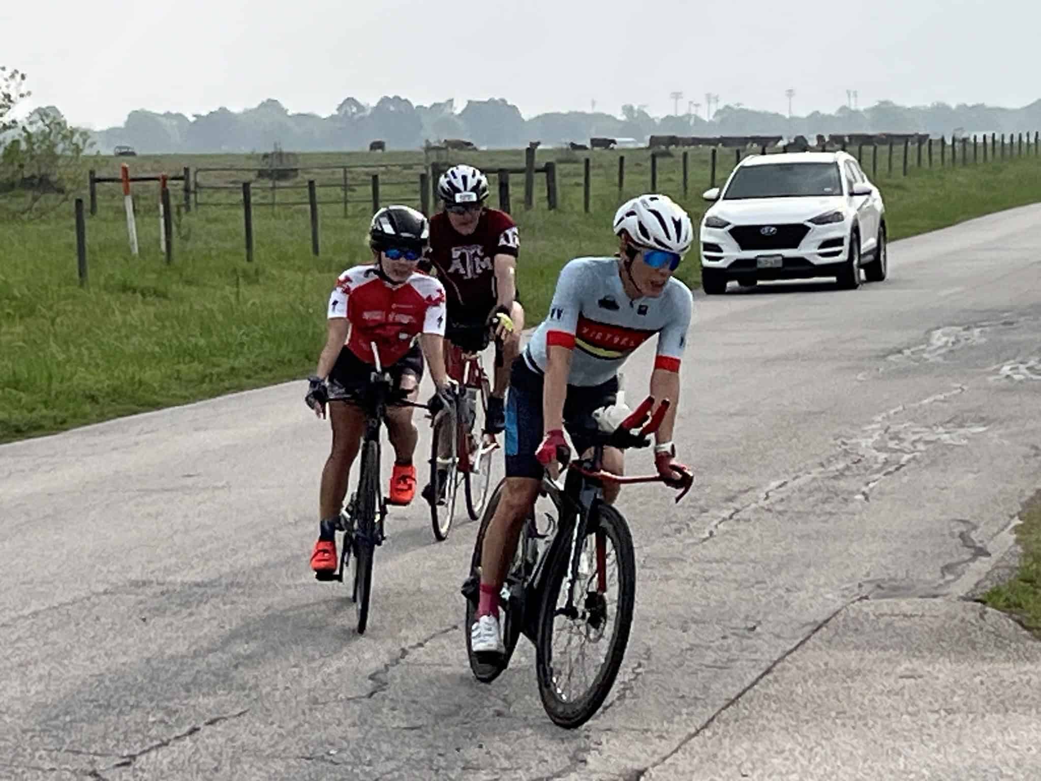 Stylish cyclists riding on a rural road, promoting Bluebonnet Express biking event and Texas cycling tours.