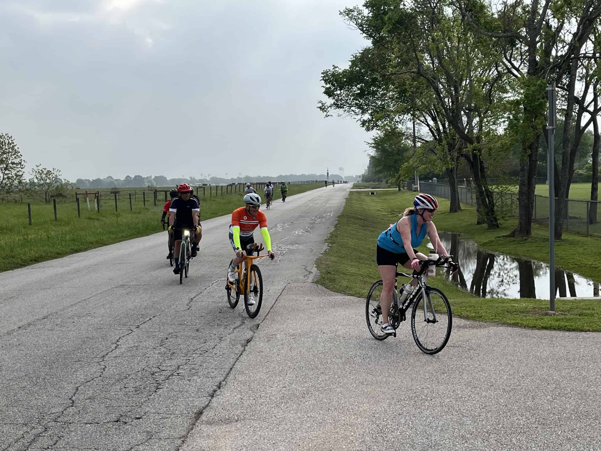 Brightly colored cyclists enjoying a scenic ride on a trail in natural surroundings.