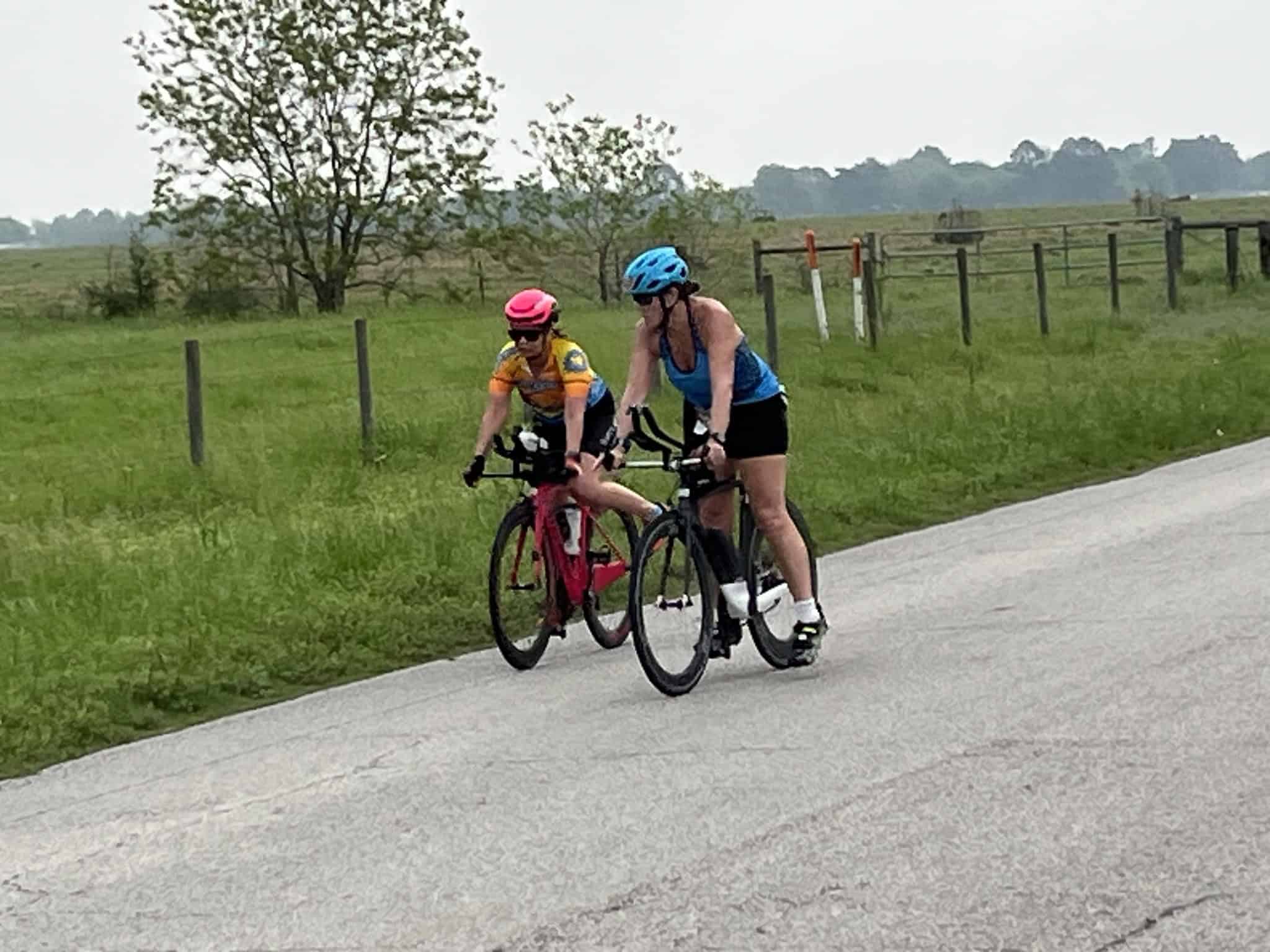 Brightly colored cyclists enjoying a ride on a scenic rural bike trail.