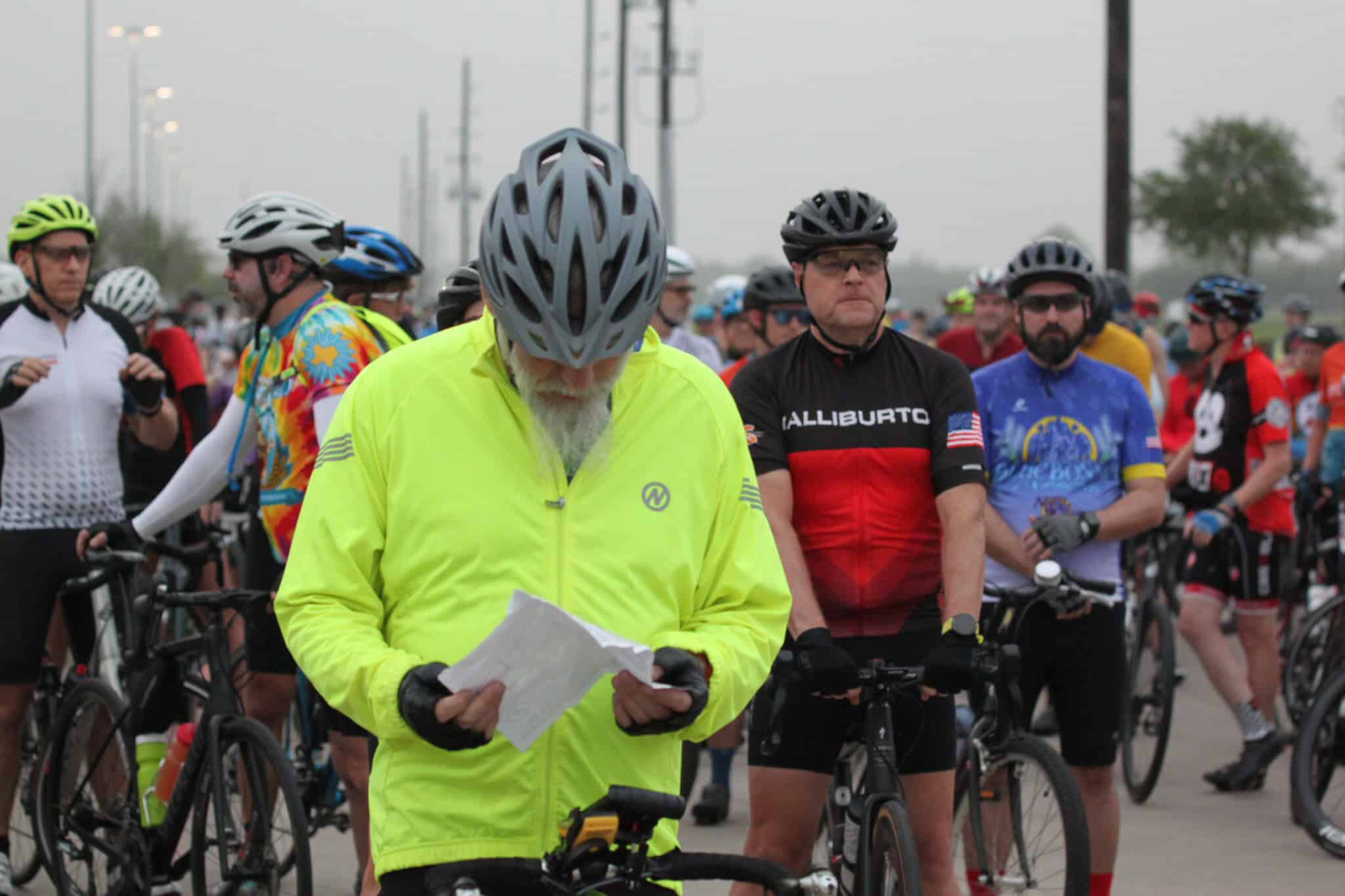 Cyclists preparing for Bluebonnet Express bike ride in Texas, wearing helmets and colorful jerseys.