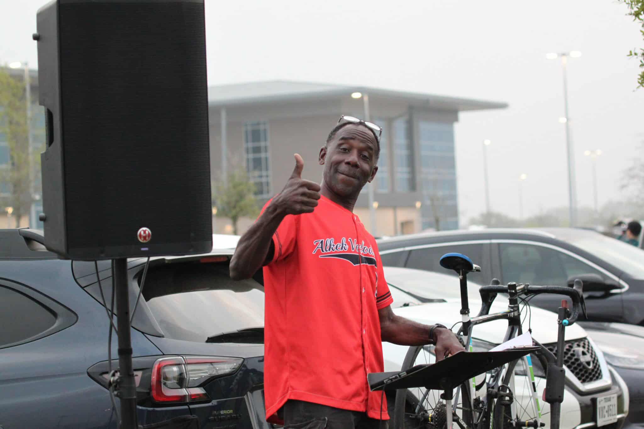 E-bike delivery rider giving thumbs up at Bluebonnet Express event in a parking lot.