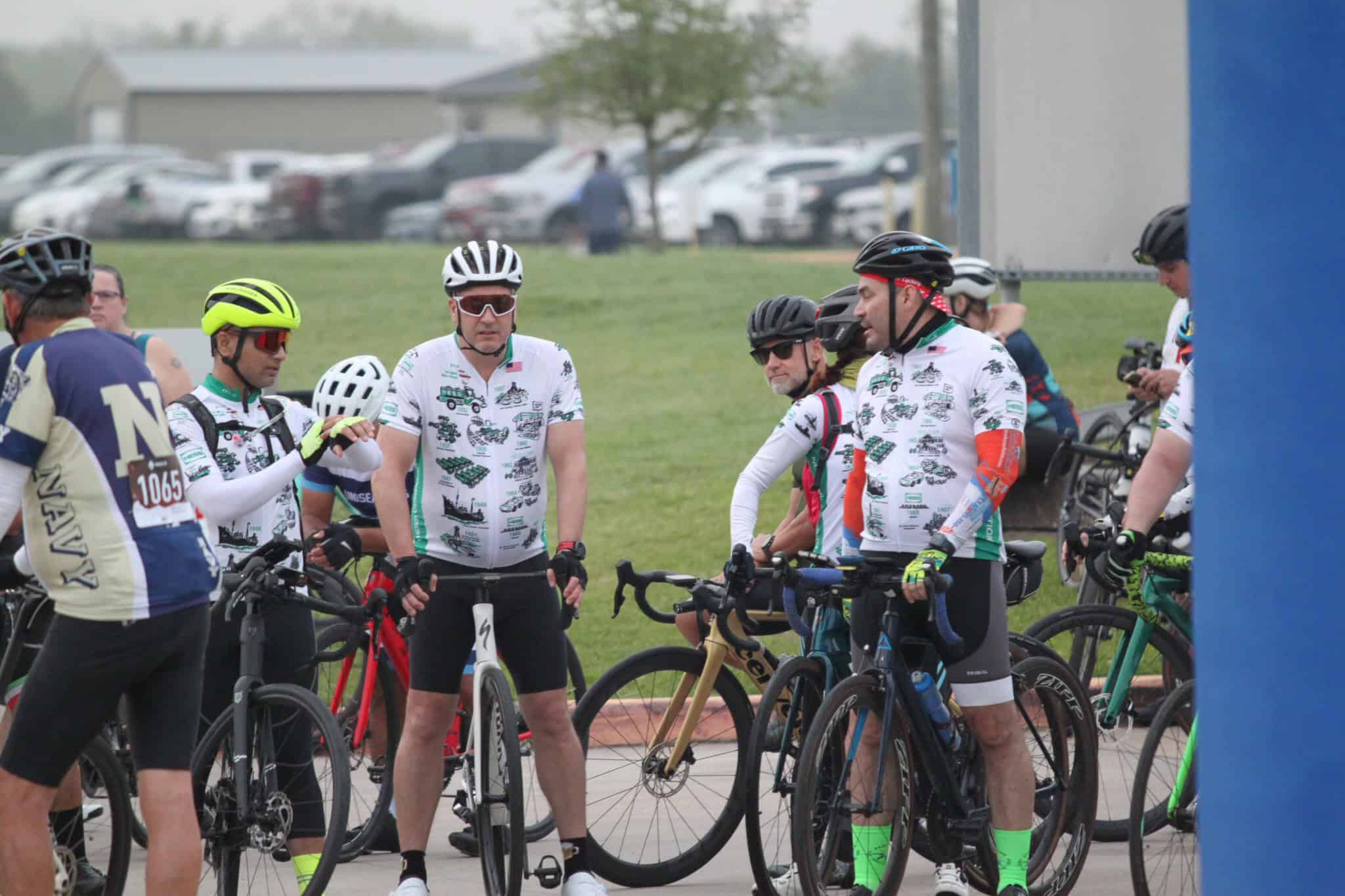 Cyclists preparing for the Bluebonnet Express cycling event in Texas, engaging in pre-ride discussions.