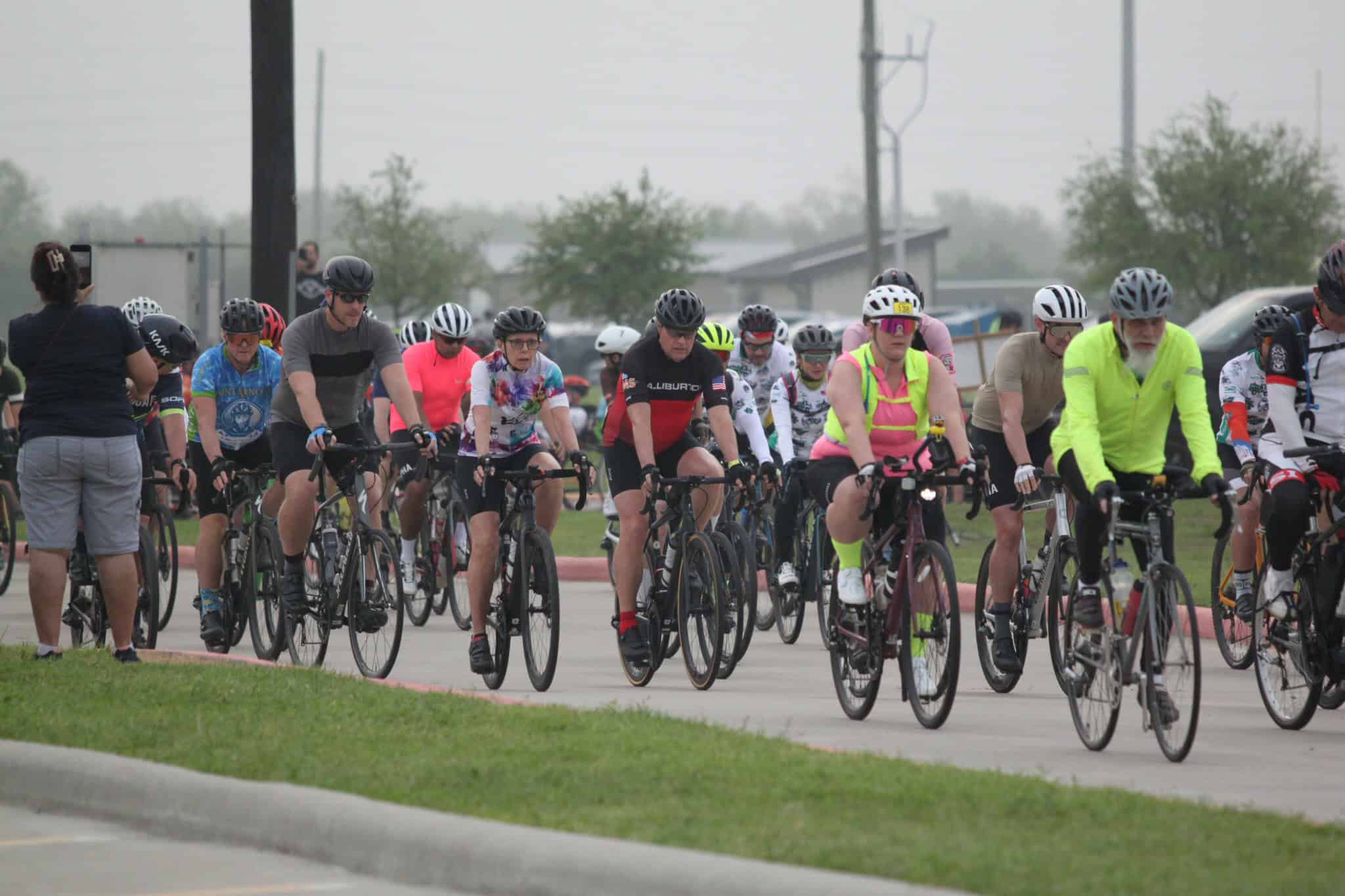 Cyclists participating in Bluebonnet Express bike event on a cloudy day, promoting cycling and community health.