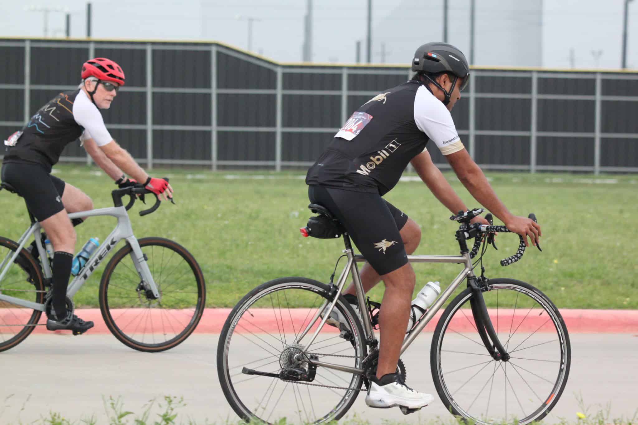 Sporty cyclists riding on a track, promoting Bluebonnet Express bike services and eco-friendly transportation.