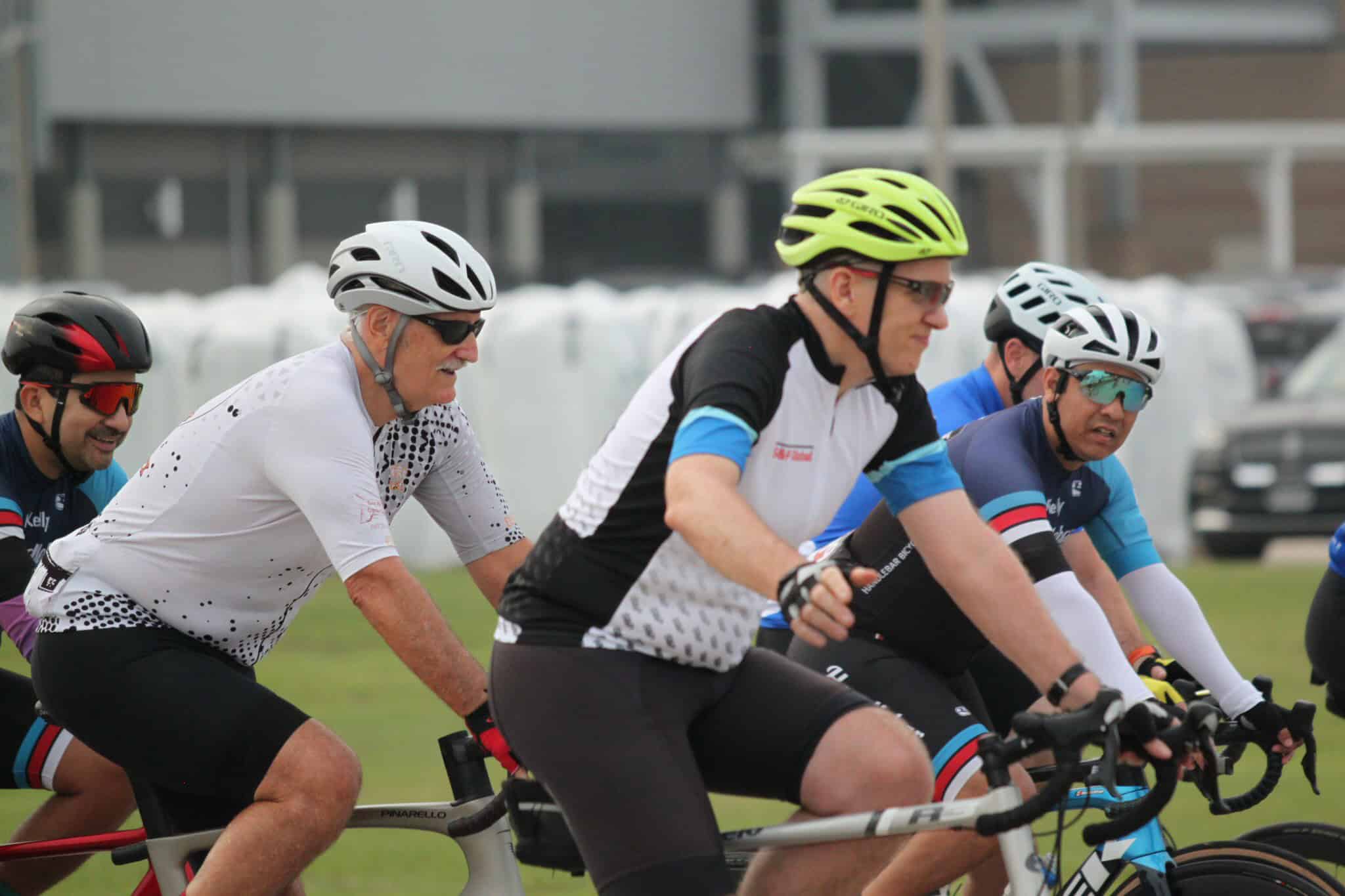 Cycling group wearing helmets and sportswear riding together in a race or event.