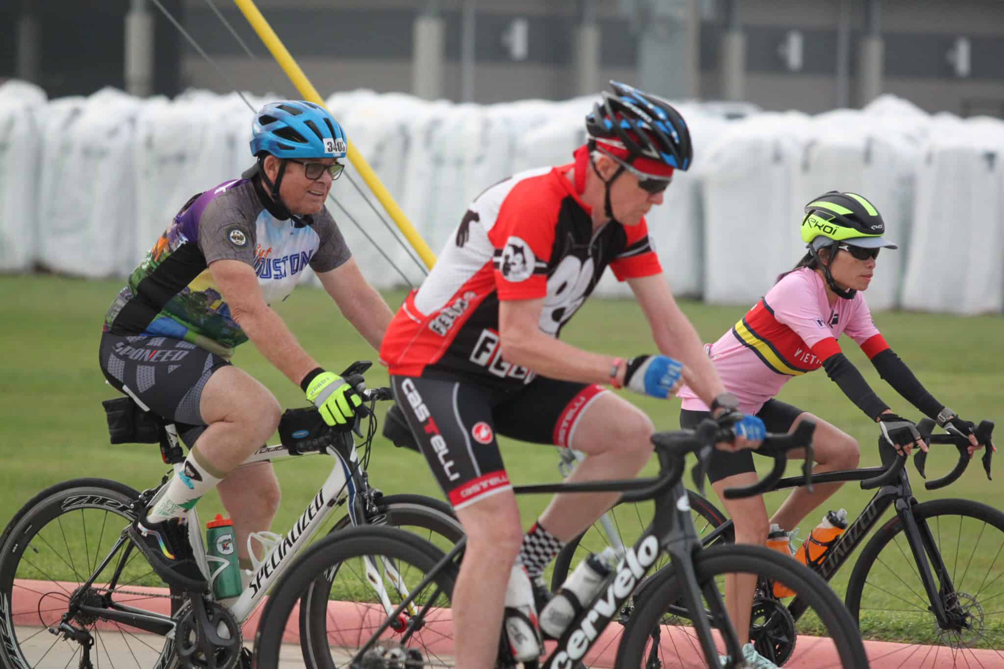 Vibrant group of cyclists racing on track during a cycling event with colorful jerseys and helmets.
