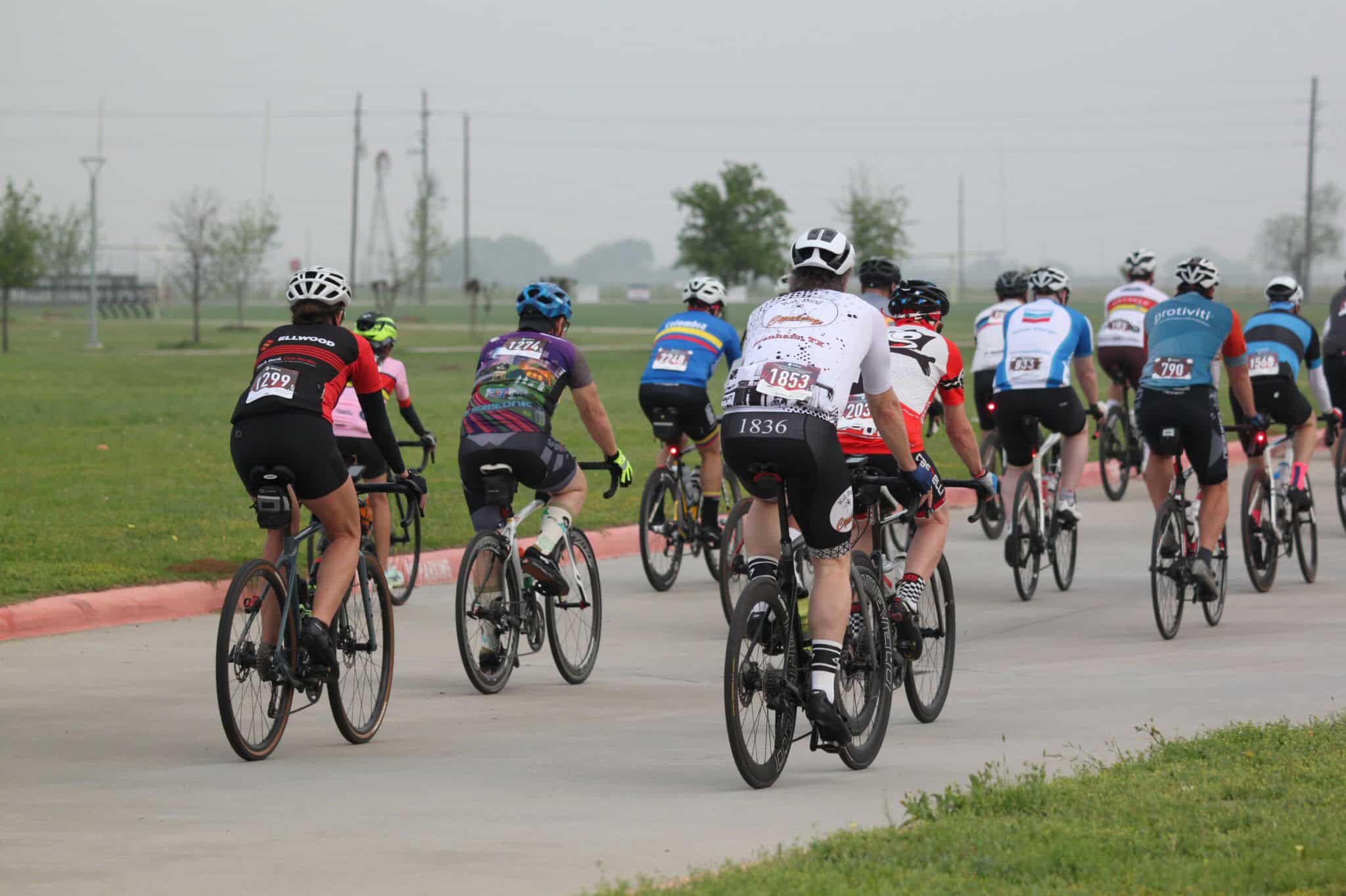 Cycling group ride at Bluebonnet Express event, showing a diverse team of cyclists on a paved trail.