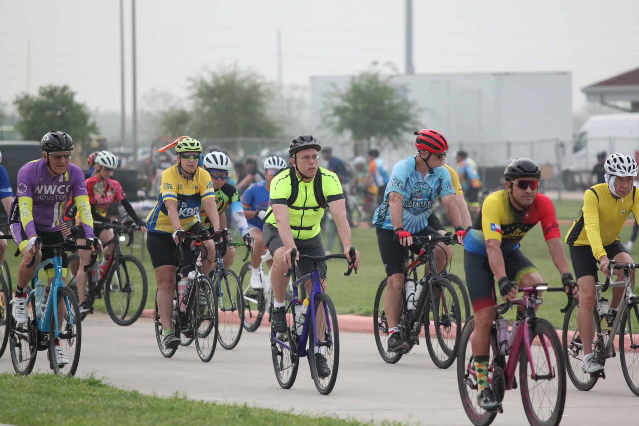 Brightly dressed cyclists participating in a group bike ride event, promoting community and outdoor fitness.