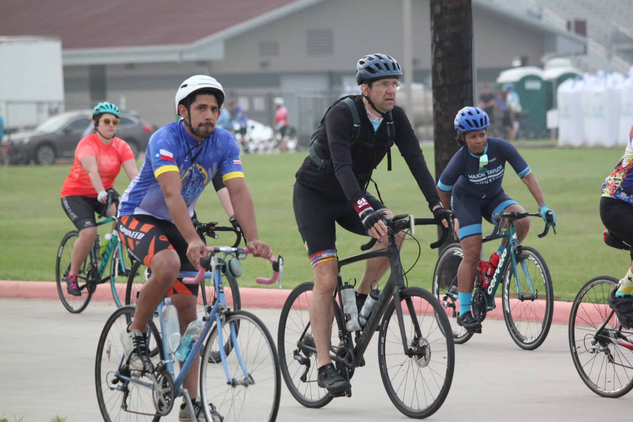 Bike riders participating in Bluebonnet Express event, cycling on outdoor roads with safety gear.
