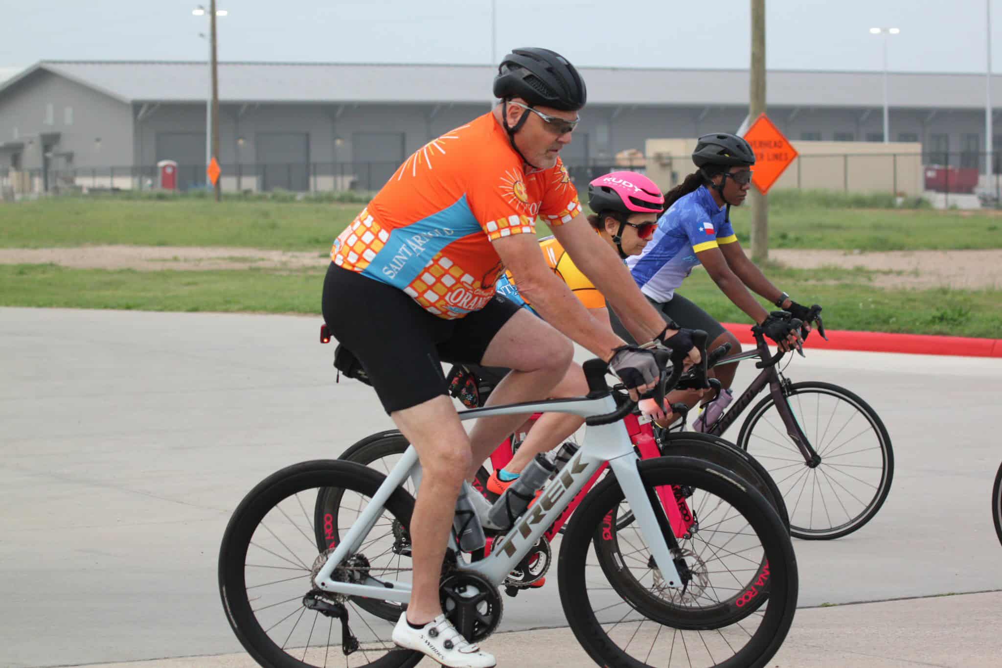 Brightly colored cyclists riding on a bike trail, promoting Bluebonnet Express cycling tour.