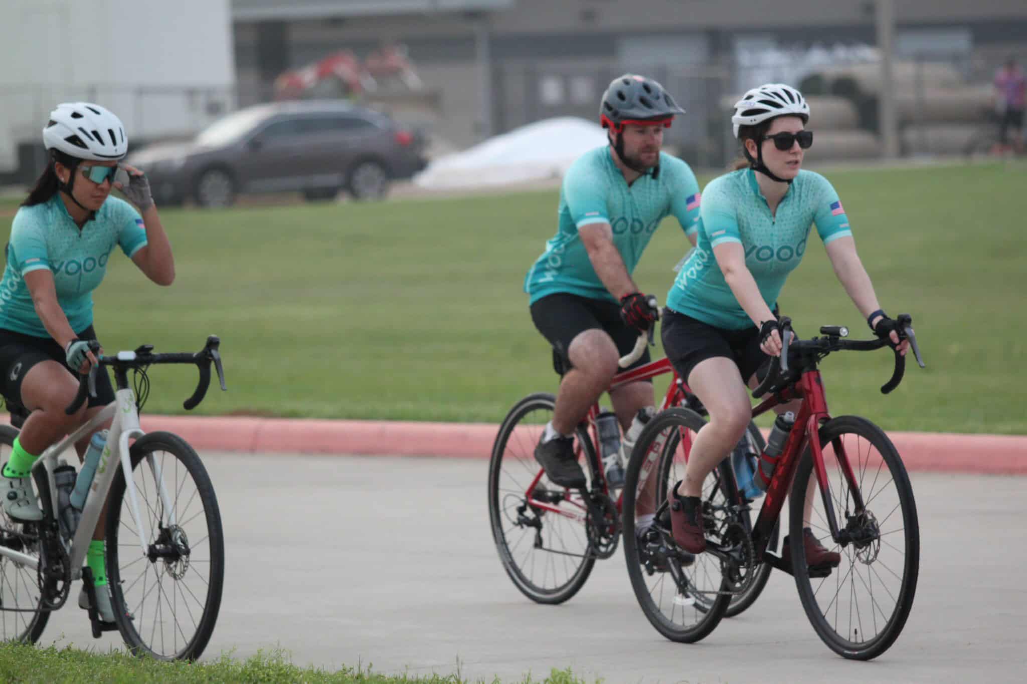 Cyclists enjoying a ride outdoors in Bluebonnet Express cycling jerseys on a sunny day.