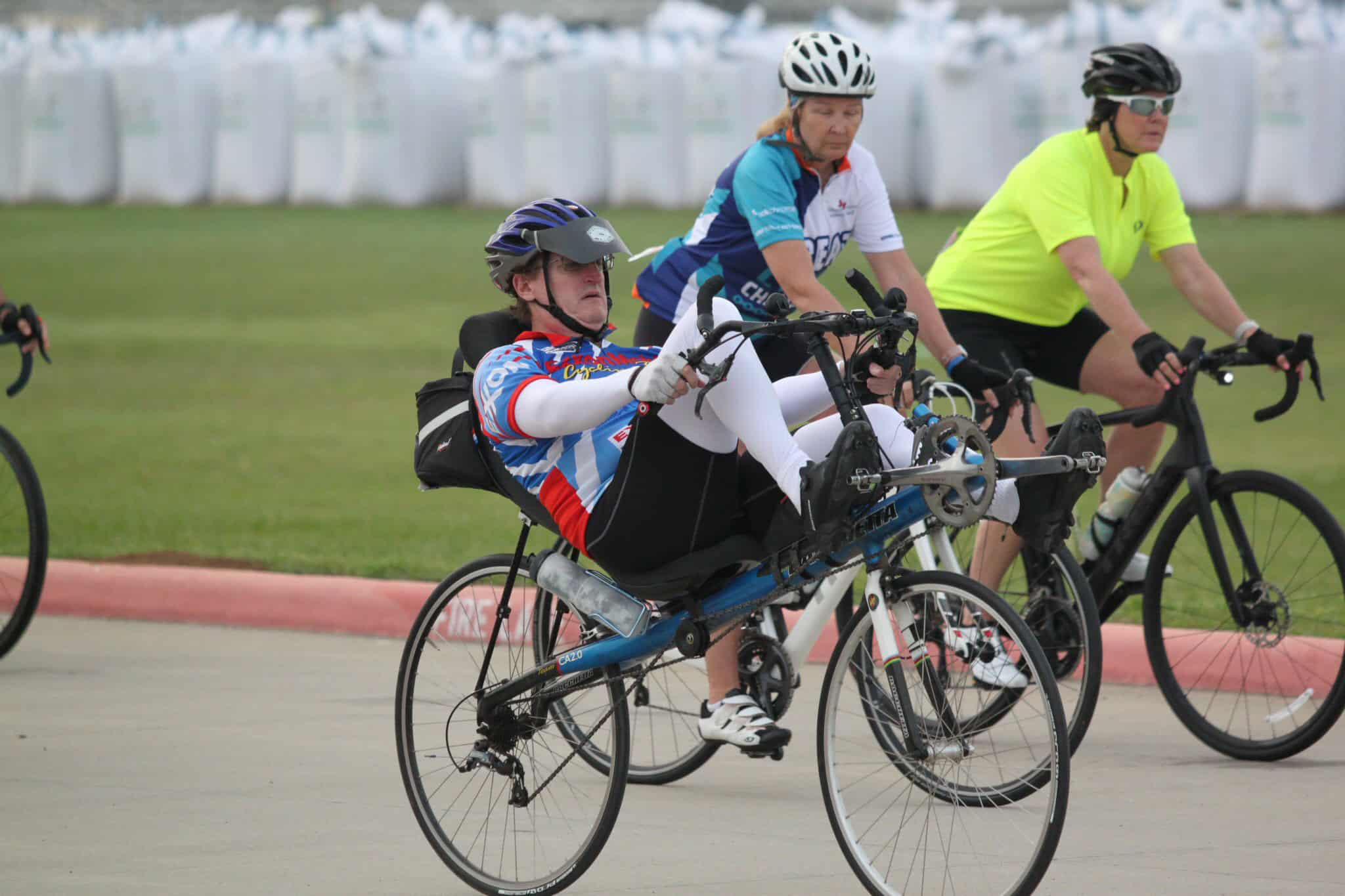 Helmeted woman on adaptive tilt bike during Bluebonnet Express cycling event in Texas.