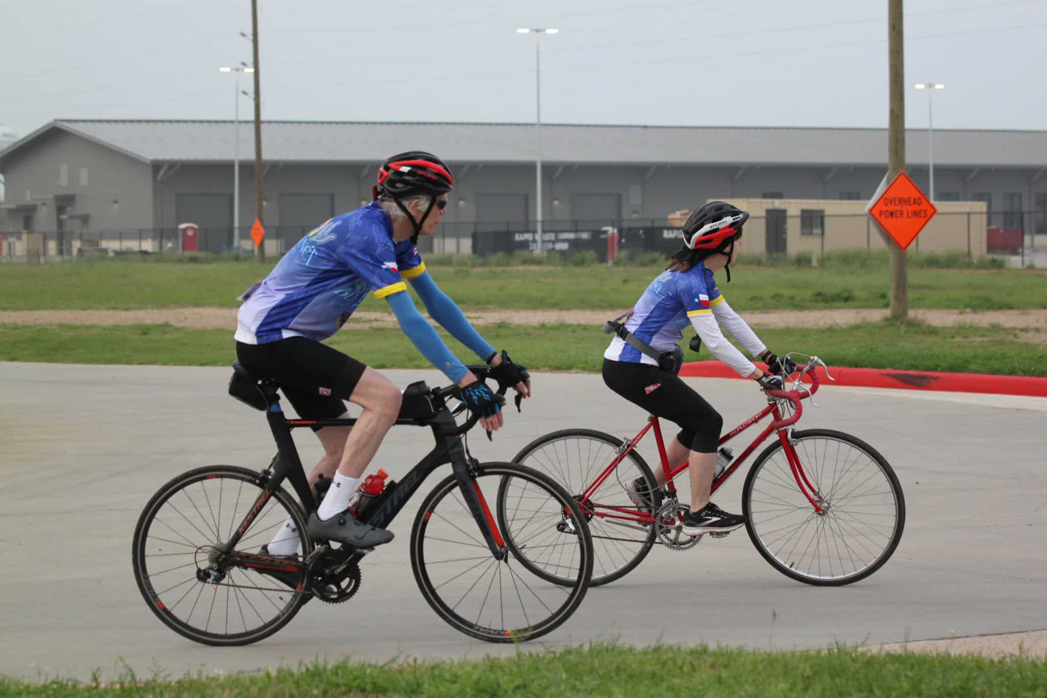 Bike riders enjoying a scenic ride on a cloudy day, promoting Bluebonnet Express bike tours and eco-friendly transportation.