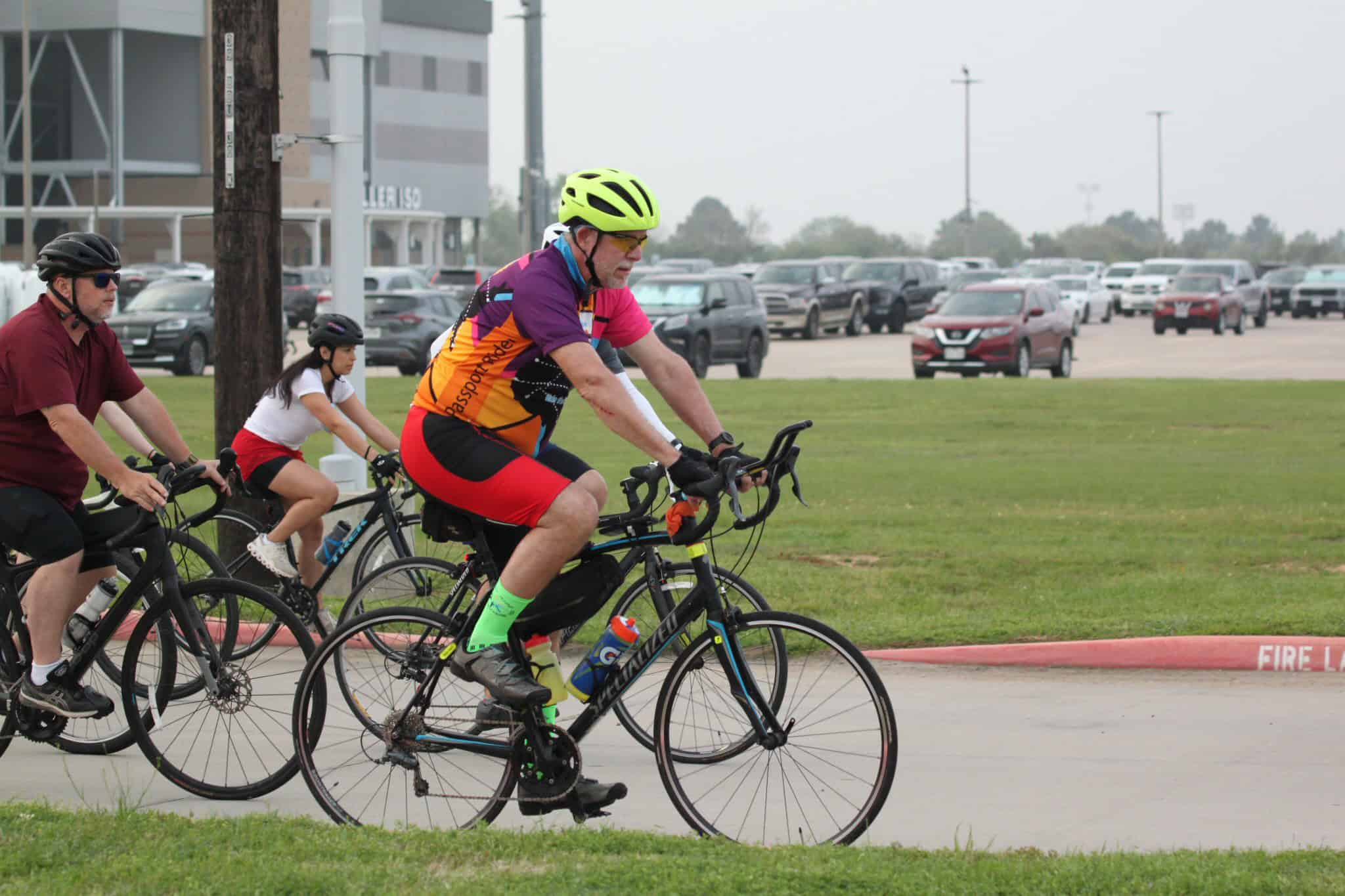 Vibrant cyclists enjoying a group ride on bicycles, promoting Bluebonnet Express cycling events and outdoor activity.