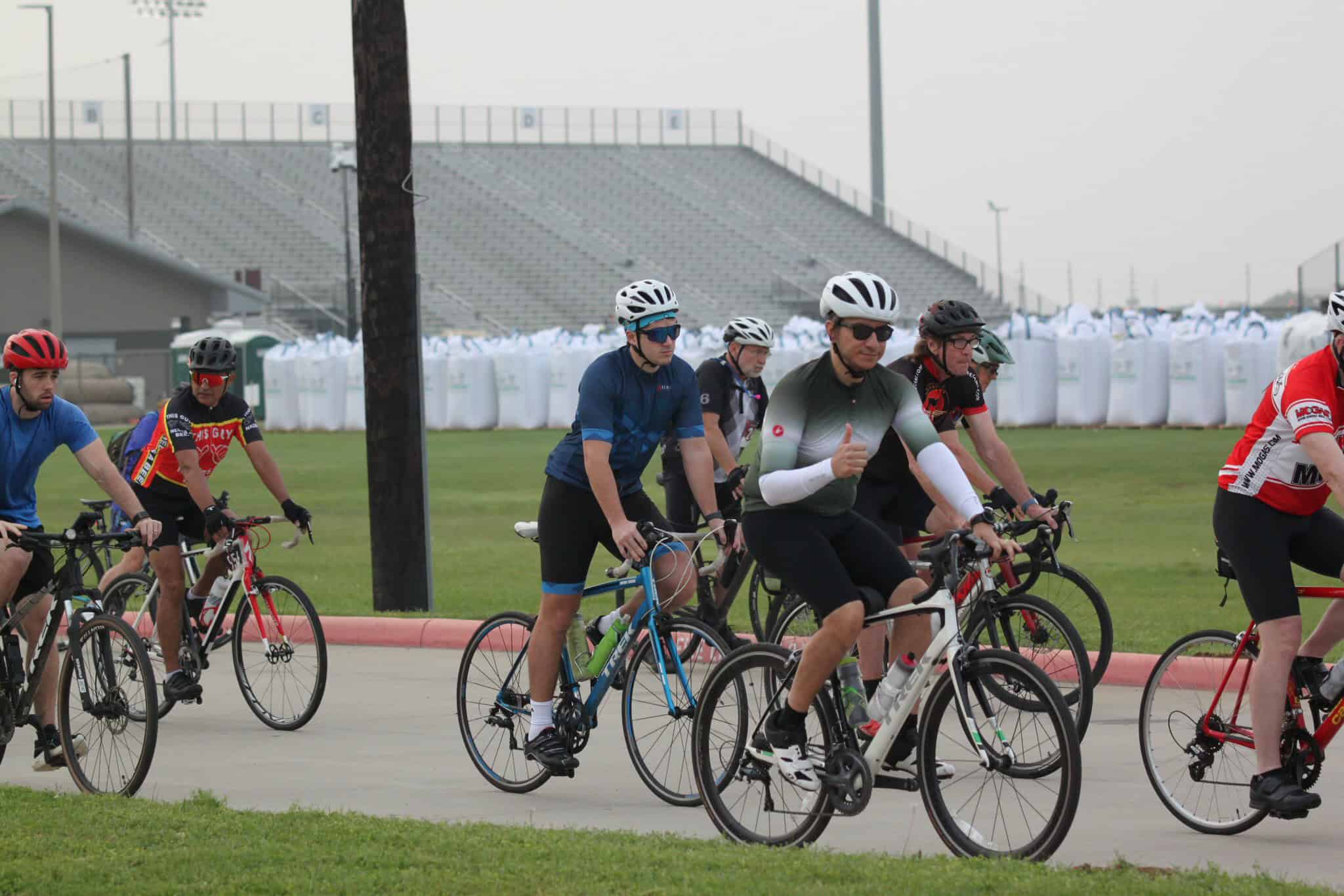 Bike riders at Bluebonnet Express cycling event on a cloudy day.