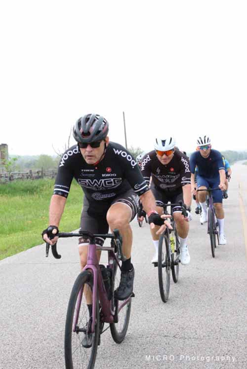 High-performance cyclists riding on a rural road during Bluebonnet Express race.