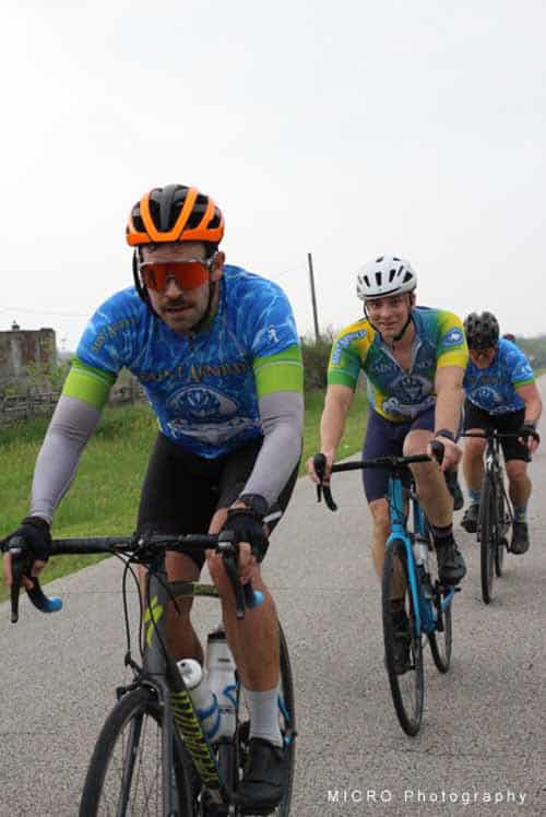 Brightly dressed cyclists pedaling on open road during Bluebonnet Express event.