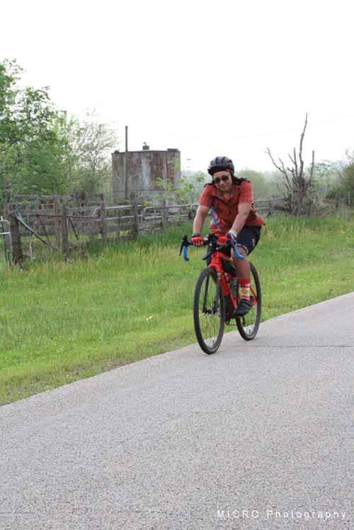 Bright red road bike rider enjoying outdoor cycling on scenic trail.
