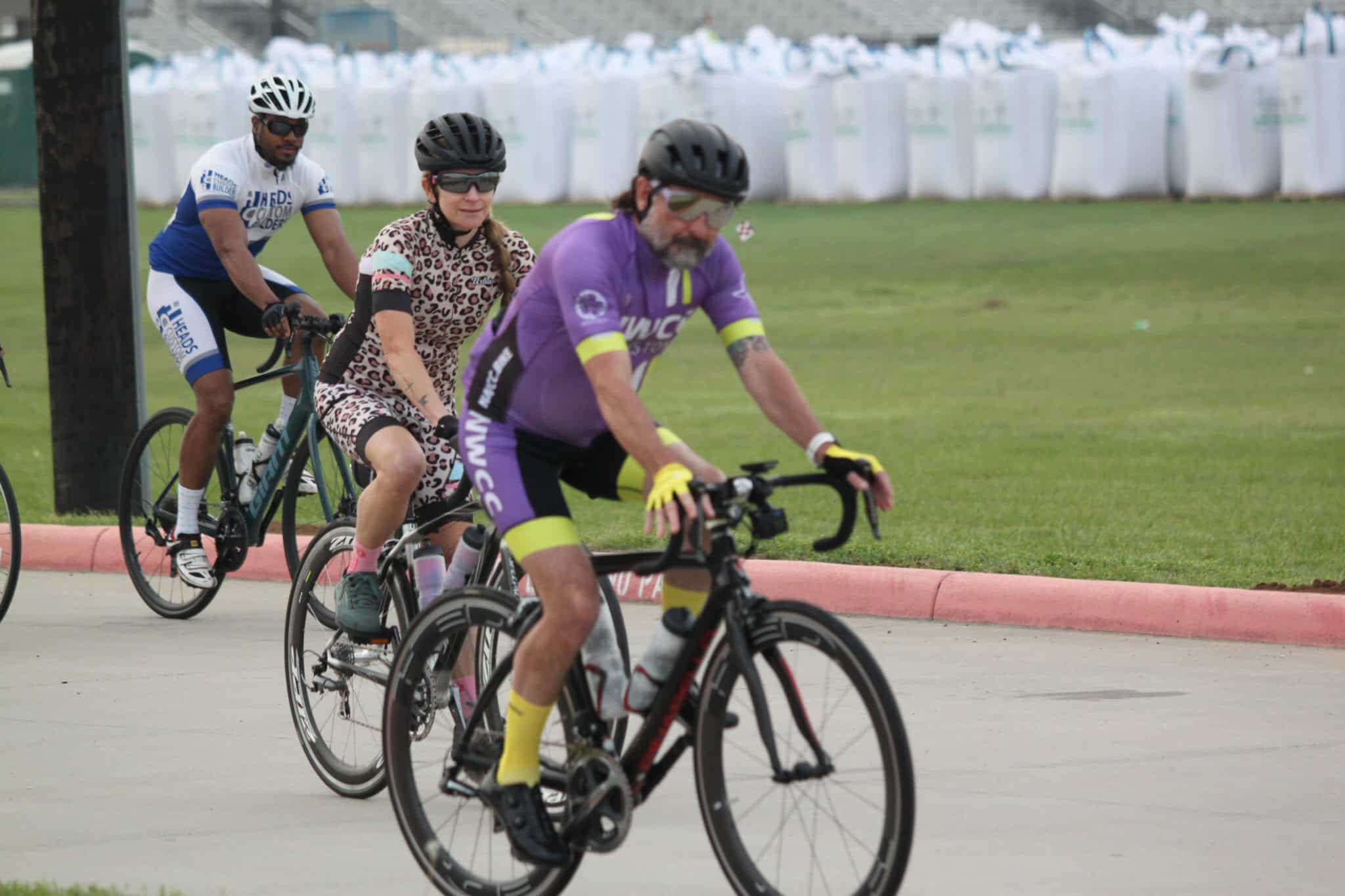 Velo cyclists riding in a charity race during daytime, promoting eco-friendly transportation.