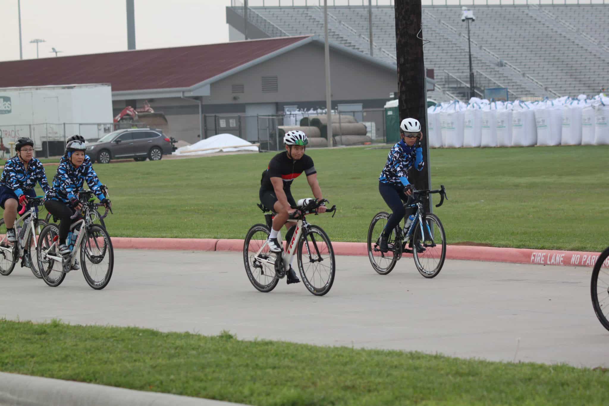 Bike riders participating in the Bluebonnet Express cycling event, enjoying a community ride in a park setting.
