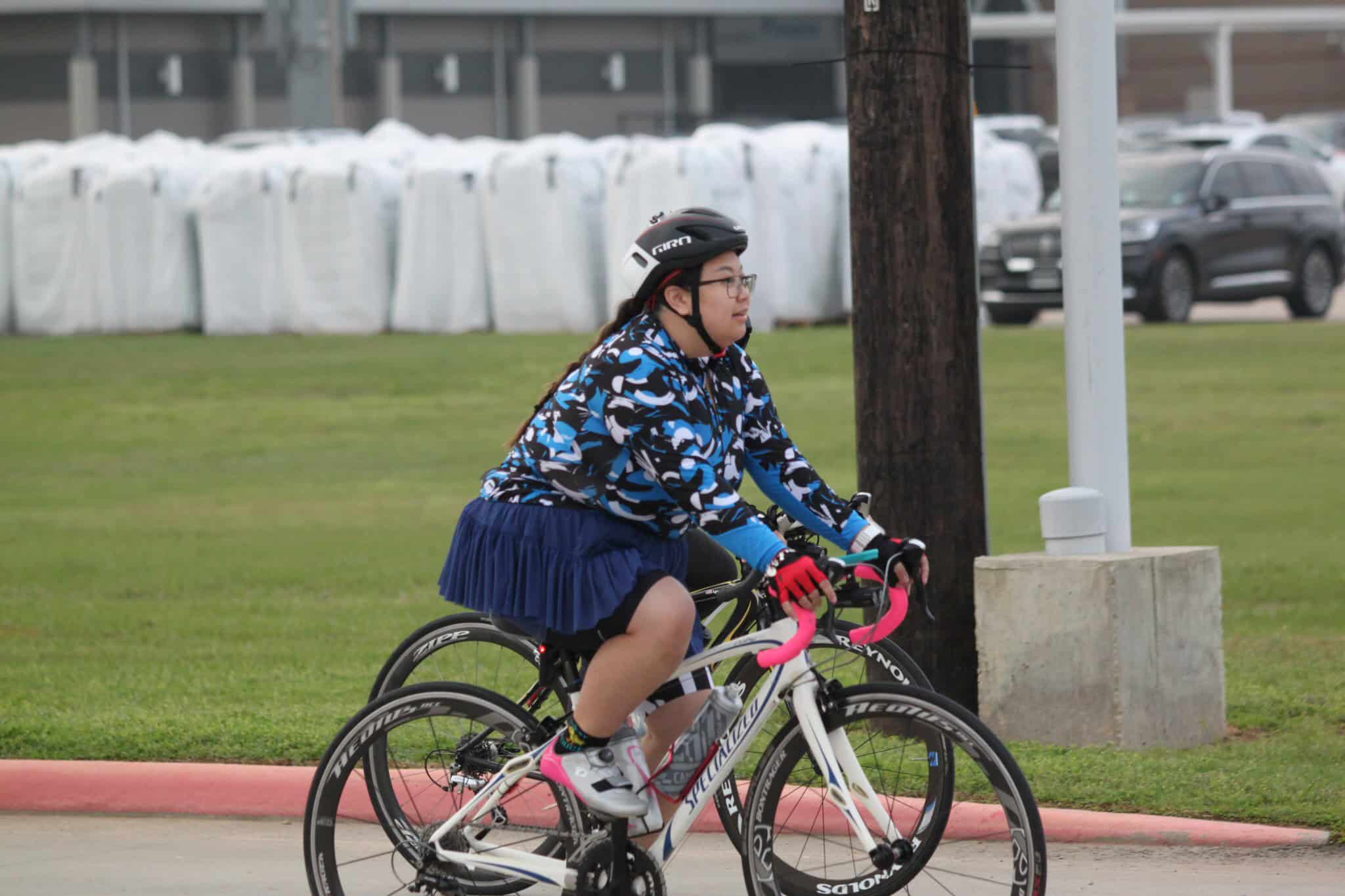Colorful women's cycling bike with pink handlebars and sporty gear.