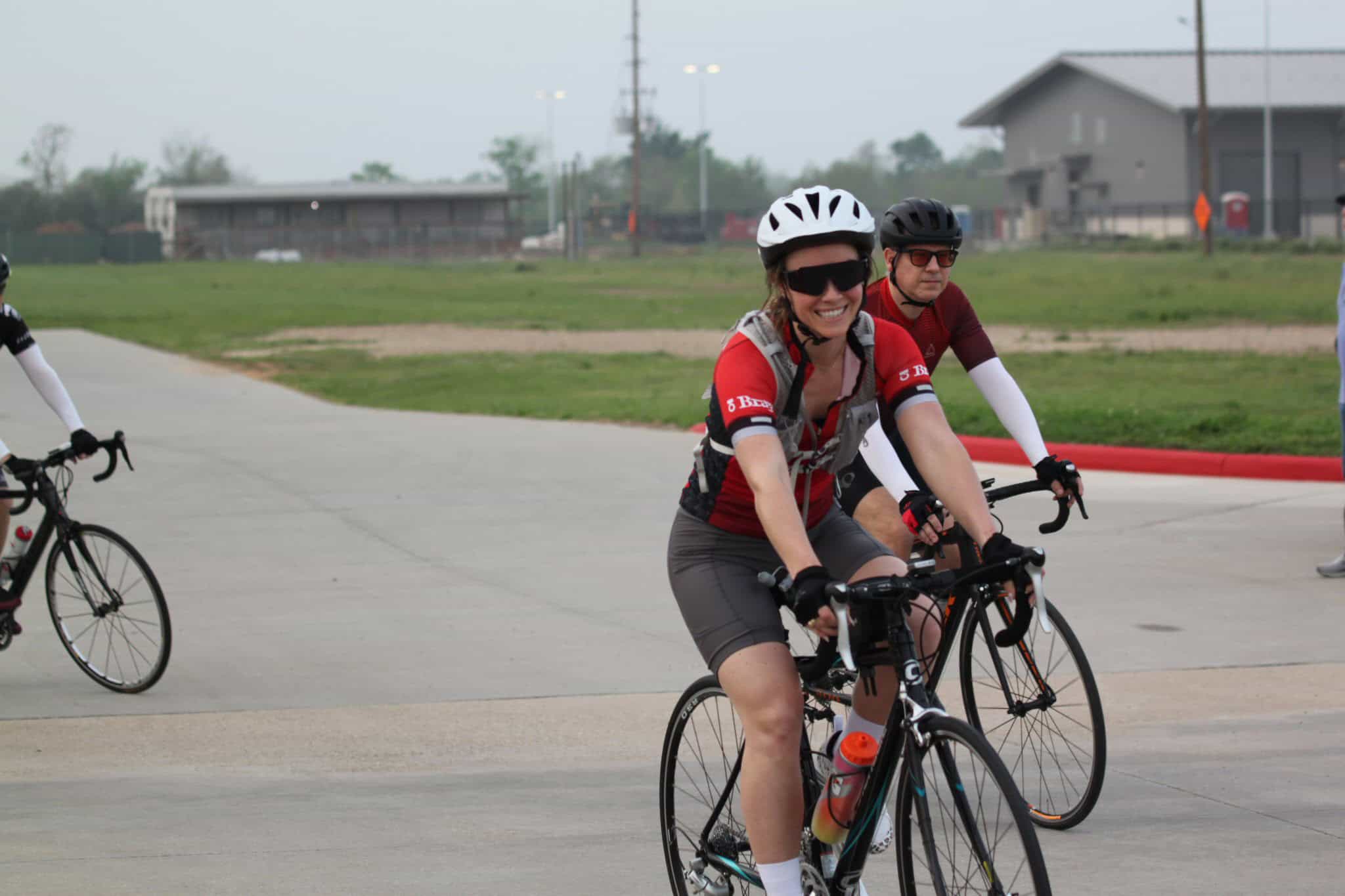 Bright smiling cyclist participating in Bluebonnet Express bike ride event, wearing safety gear, sunny day outdoor cycling.